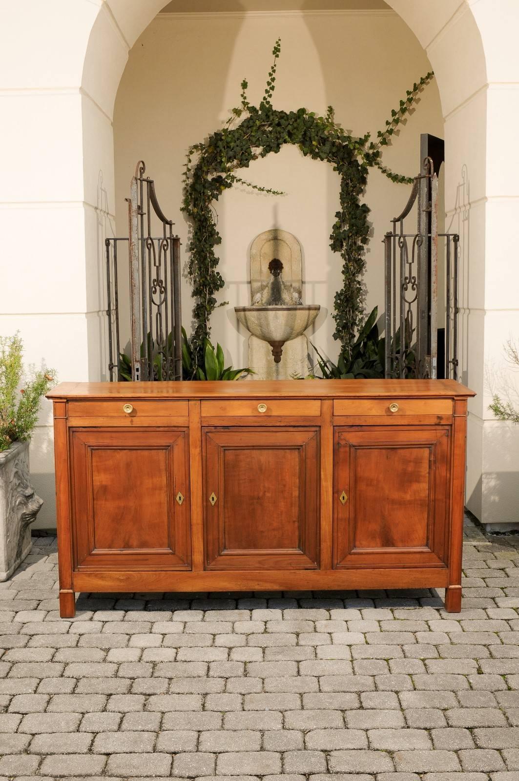 A French narrow wooden three-door enfilade with three drawers from the late 19th century. This French wooden enfilade, born in the later years of the 19th century, features a rectangular top with framing planks, sitting above three thin drawers with