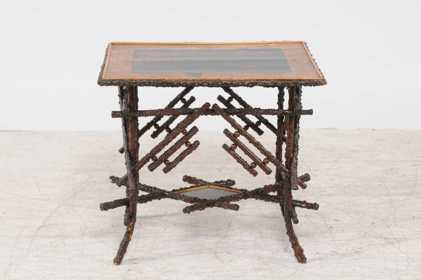 An English Chinese Chippendale style briar wood side table with unusual top and lower shelf from the late 19th century. This English side table features an eye-catching top adorned with various geometrical motifs surrounding a black and red central