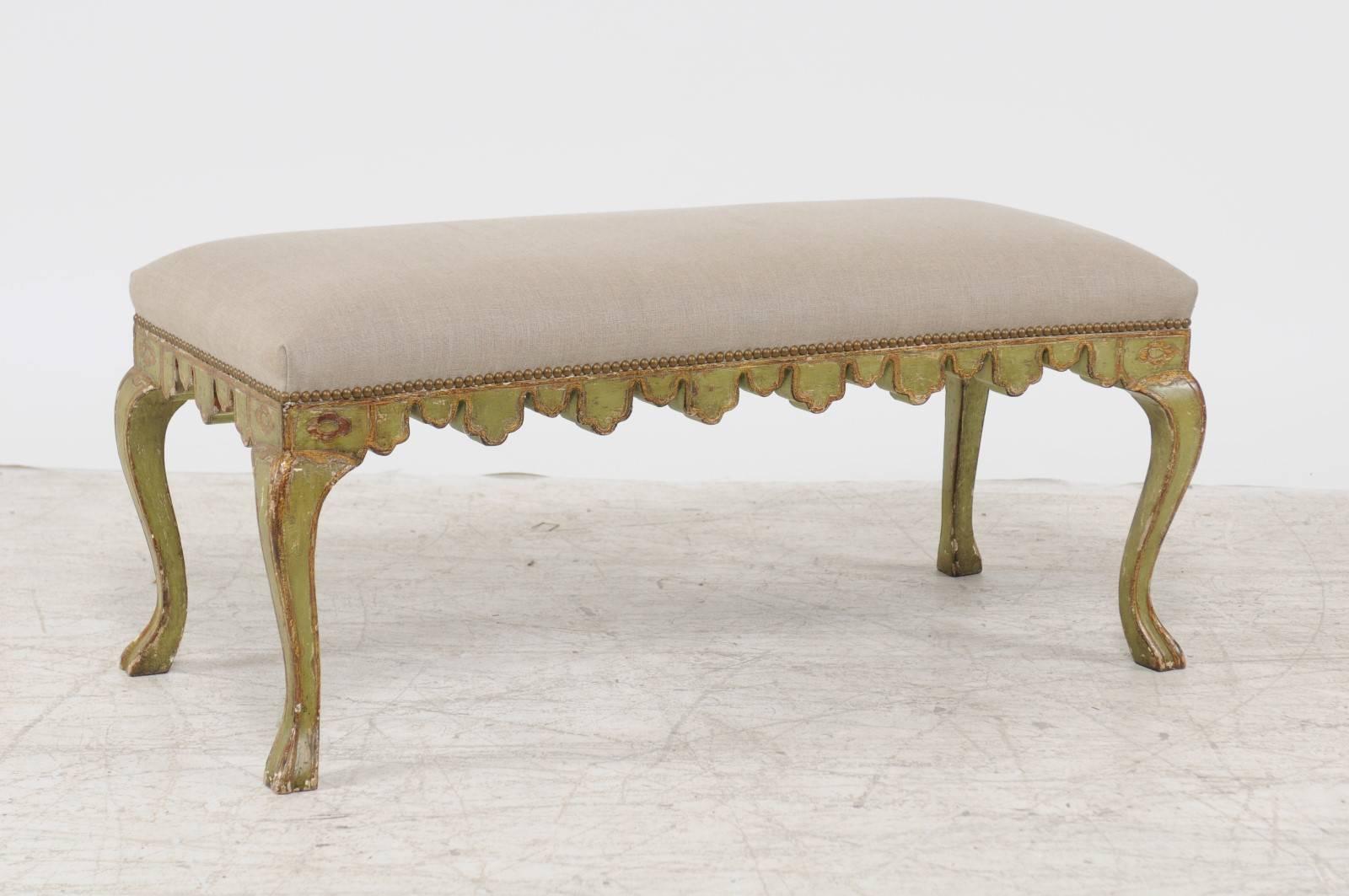 An Italian Rococo style backless painted wood bench from the first half of the 20th century, with newly recovered seat. This Italian bench features a rectangular seat, recovered with a simple linen fabric, accented on the trim with a brass nailhead