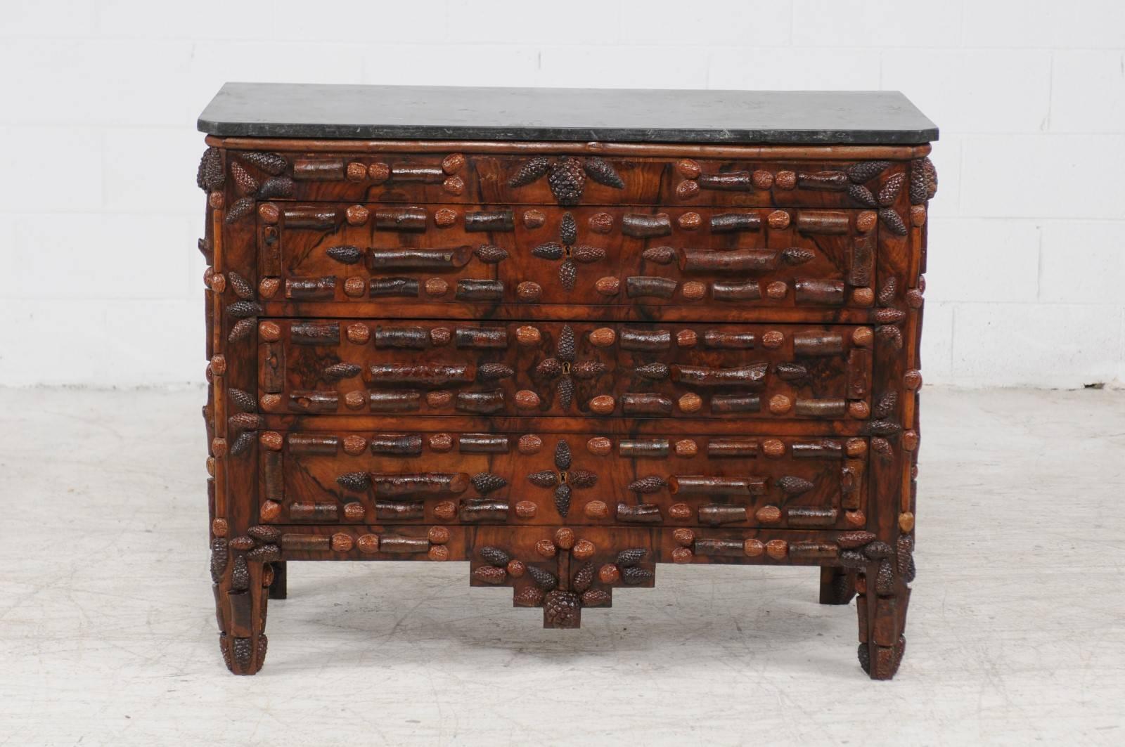 A French late 19th century walnut and pine cone three-drawer commode with dark grey marble top. This unusual French three-drawer chest features a dark grey or black rectangular marble top with canted corners in the front, sitting above a whimsical