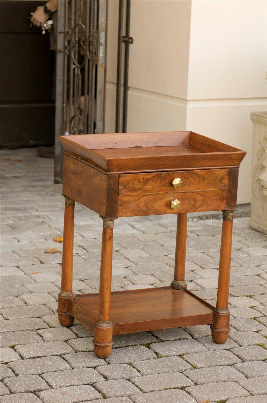 This French Empire walnut side table features a rectangular tray top over two thin drawers, one in the front and one in the back. To maintain a harmonious symmetry, the artist has ingeniously placed a faux drawer on each side to compliment the real