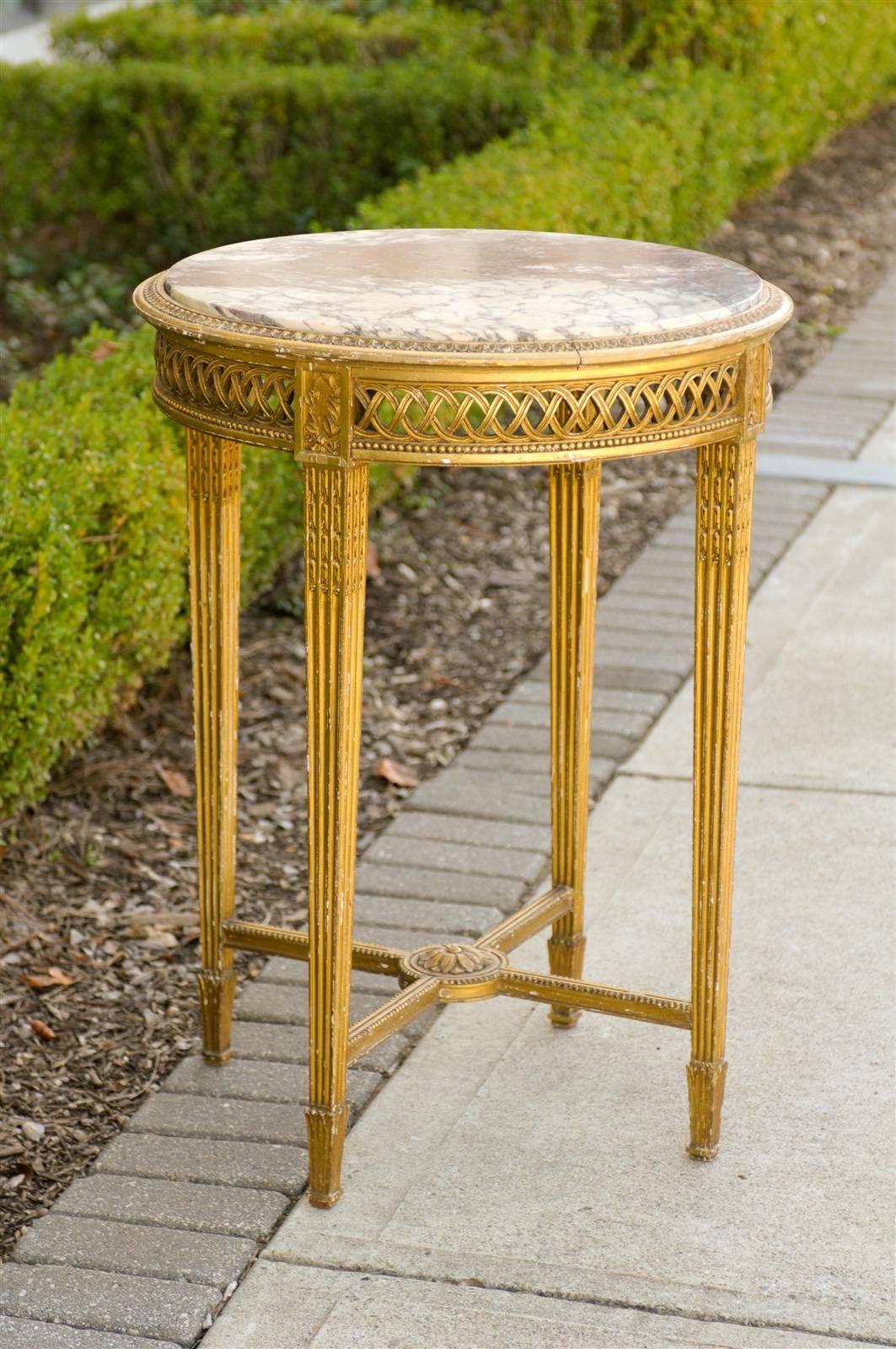 This French Napoléon III guéridon table from the 1870s features a round white and purple veined marble top over a giltwood structure. The lovely egg and dart molding surrounding the marble top sits above an intricately carved apron with a decor