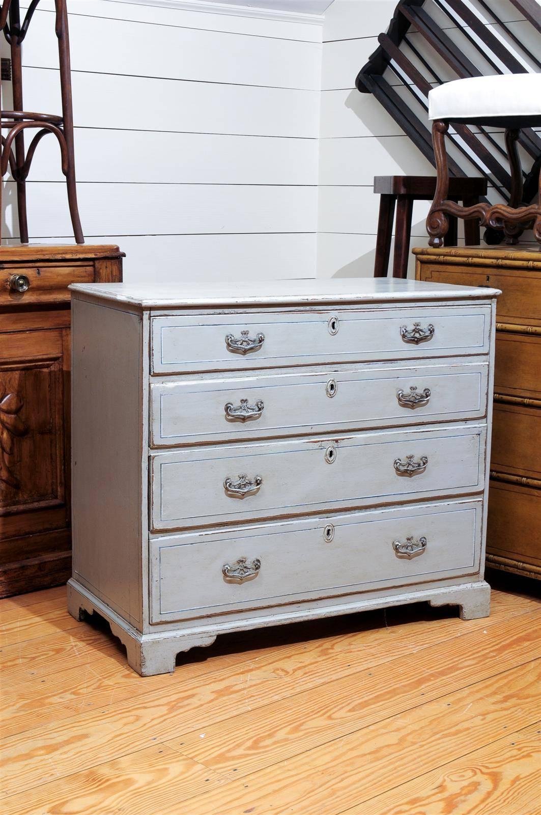 An English painted wood four-drawer chest from the 19th century. This English chest from circa 1870 features four graded and dovetailed drawers adorned with bail handles and central escutcheons. This English chest is raised on four bracket feet. The