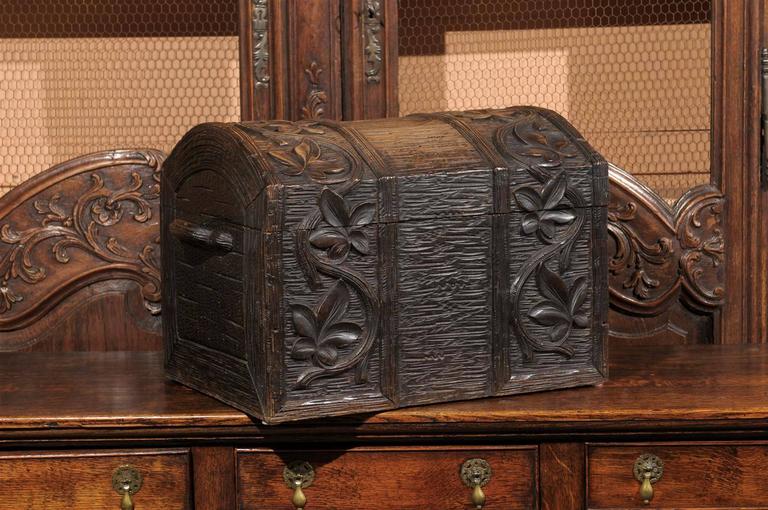 This French carved wood Black Forest trunk circa 1890-1900 features a beautifully hand-carved floral décor. The textured background is left visible in the center of the piece while elegant curvy foliage flanks the sides in the front and top of the