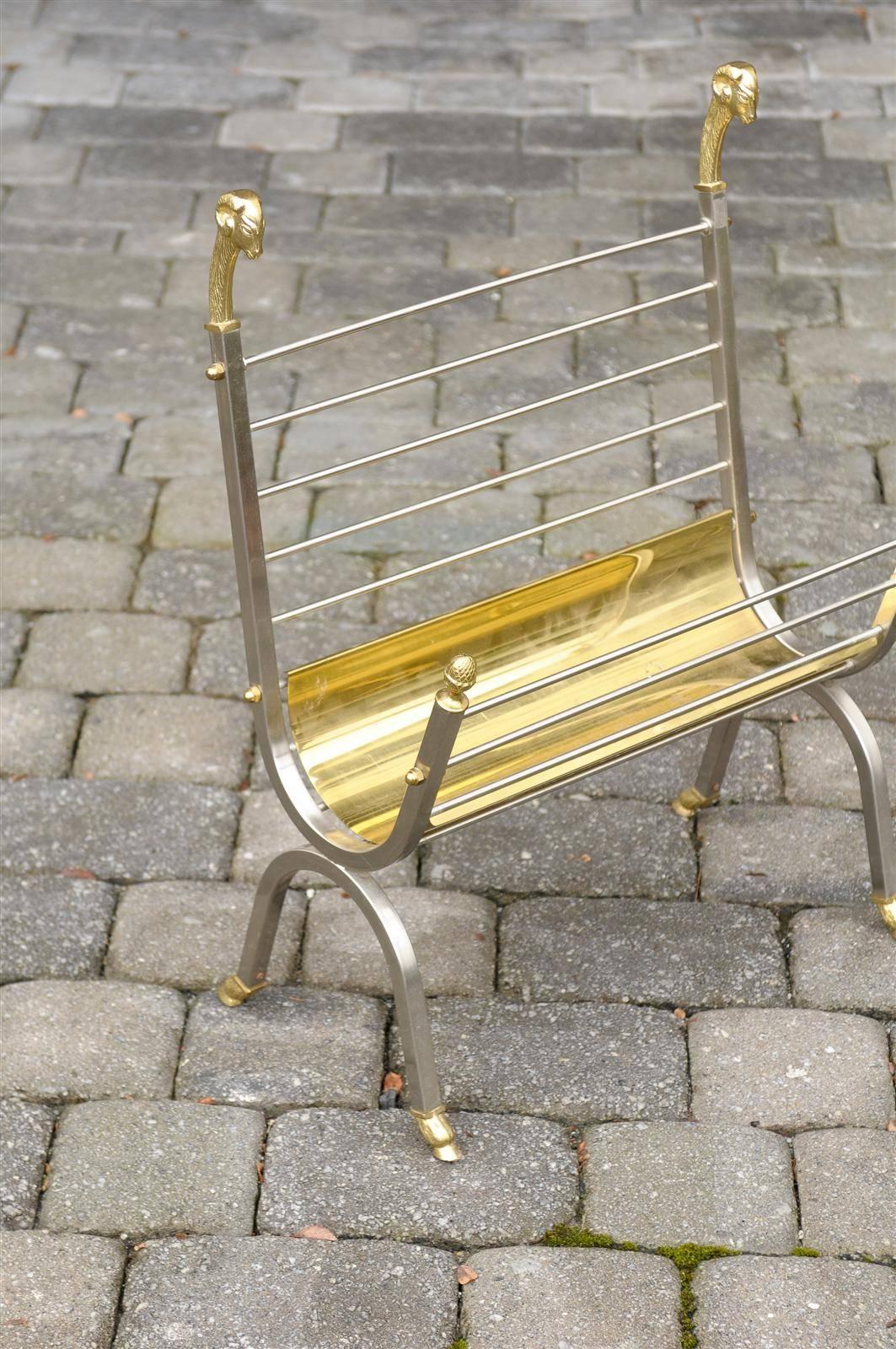 This vintage Italian magazine rack is made of steel and brass. Dated, circa 1970, it is reminiscent of Maison Jansen, in its sleek shape and use of materials. The elegant sides are adorned with discreet brass rams heads and acorn finials while the