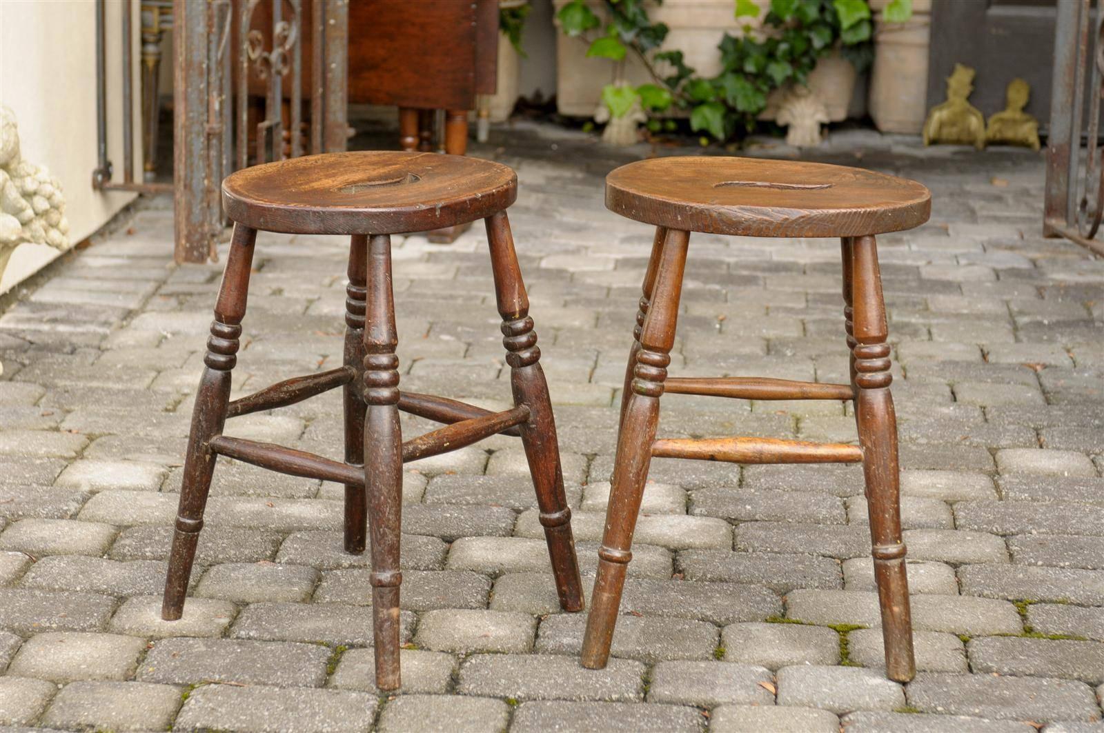 An English rustic wooden stool with oval top and carrying handle from the late 19th century. We currently have three of these stools, priced and sold separately. Each stool features an oval top with a central carved carrying handle. The ensemble is