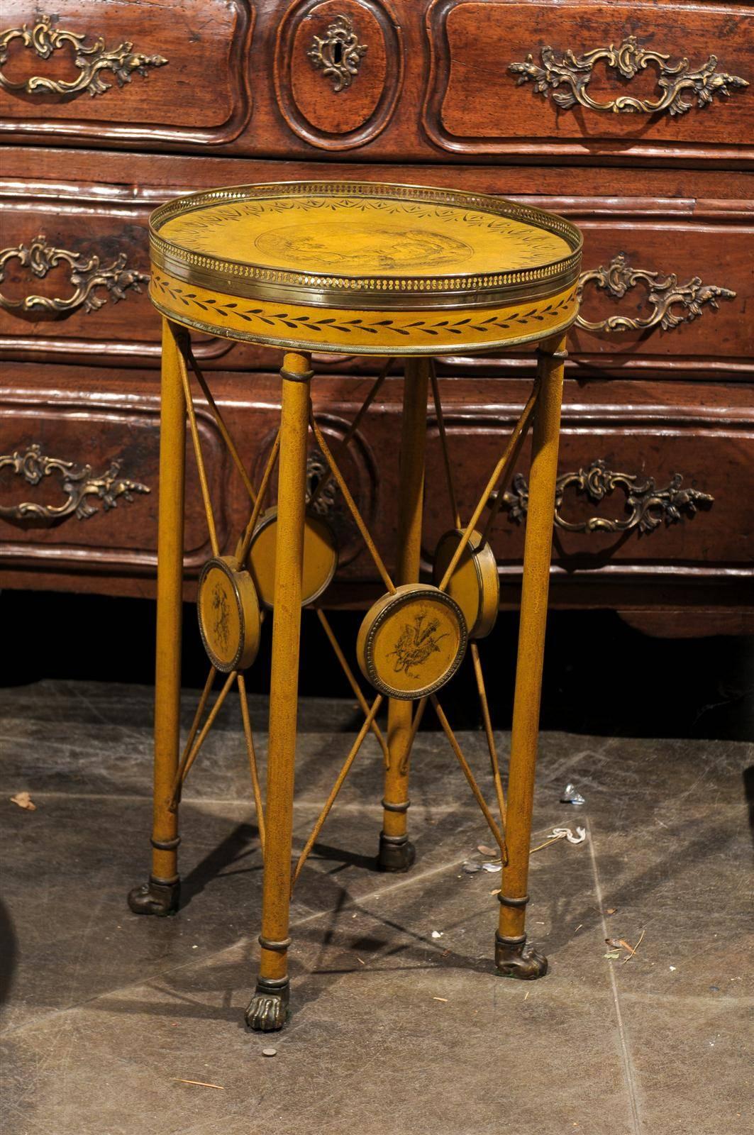 This French painted tole side table from the late 19th century features a circular top adorned with a pierced brass gallery on the surround and a delightful hand painted landscape scene in the center. The apron is adorned with floral motifs,