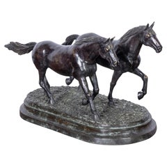Sculpture anglaise en bronze patiné représentant deux chevaux au galop, datant d'environ 1920