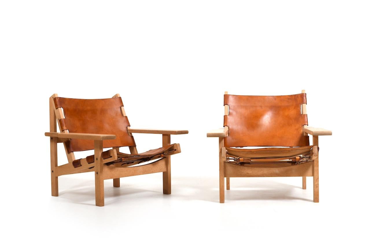 Pair of hunting chairs in solid oak and patinated cognac saddle leather by Kurt Østervig for KP Møbler Denmark 1960s. Model 168. „Jadtstol“.