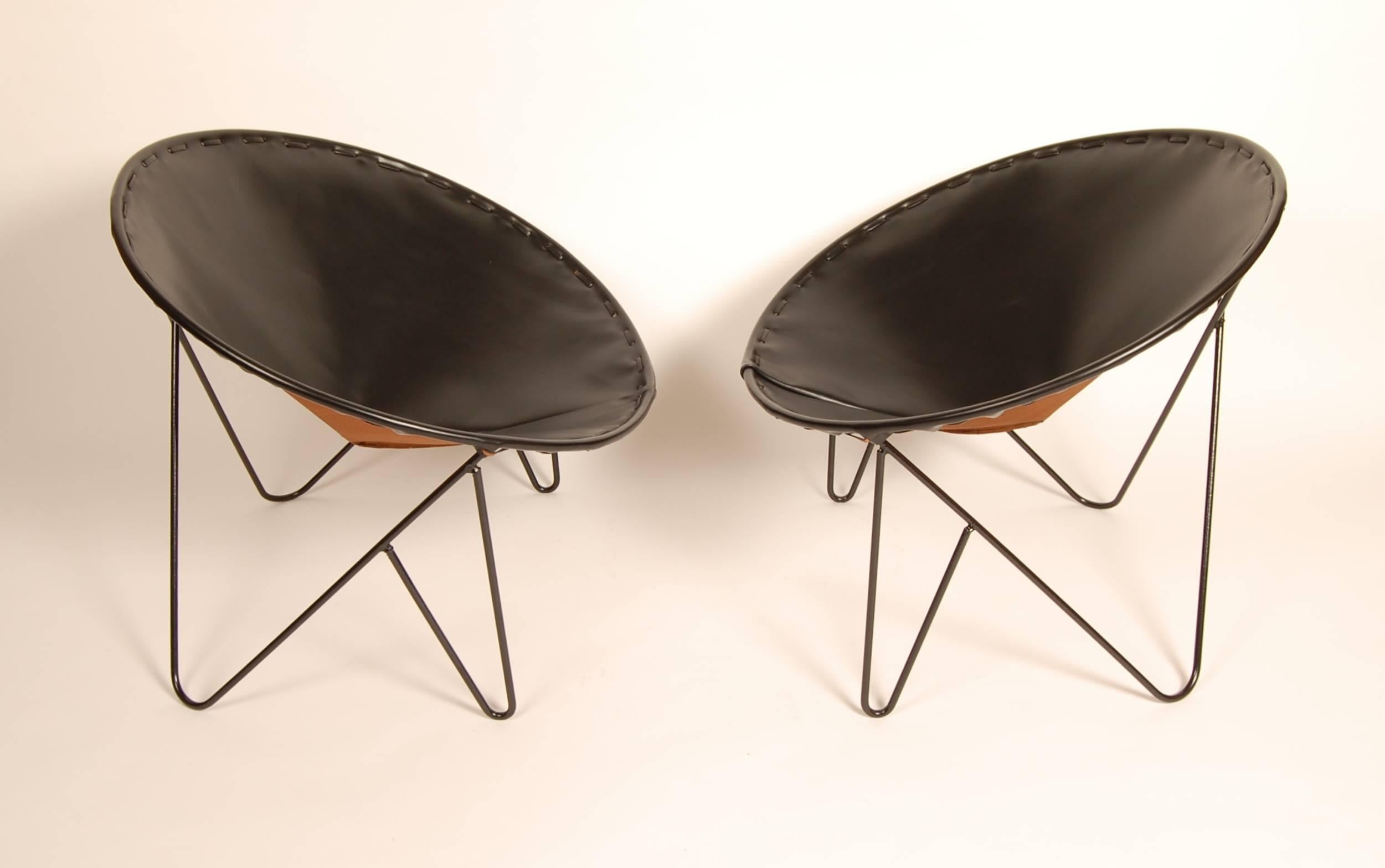 Restored 1950s iron lounge chairs with new leather upholstery and black powder-coated frames. Great geometry to the frames with new hand-stitched leather upholstery that makes them snap.