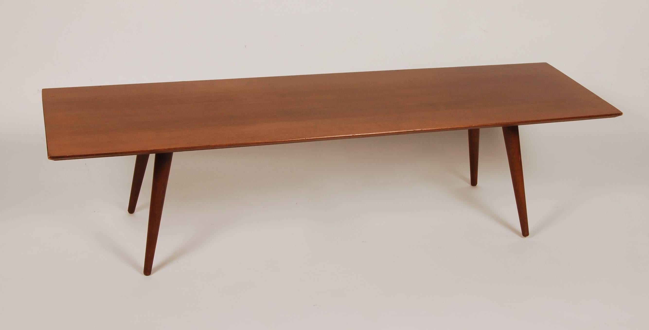 Planner Group coffee table designed by Paul McCobb which was his most well received furniture line during his long career. This example is an all original tobacco stained solid maple construction coffee table or bench with slender tapered legs, foil