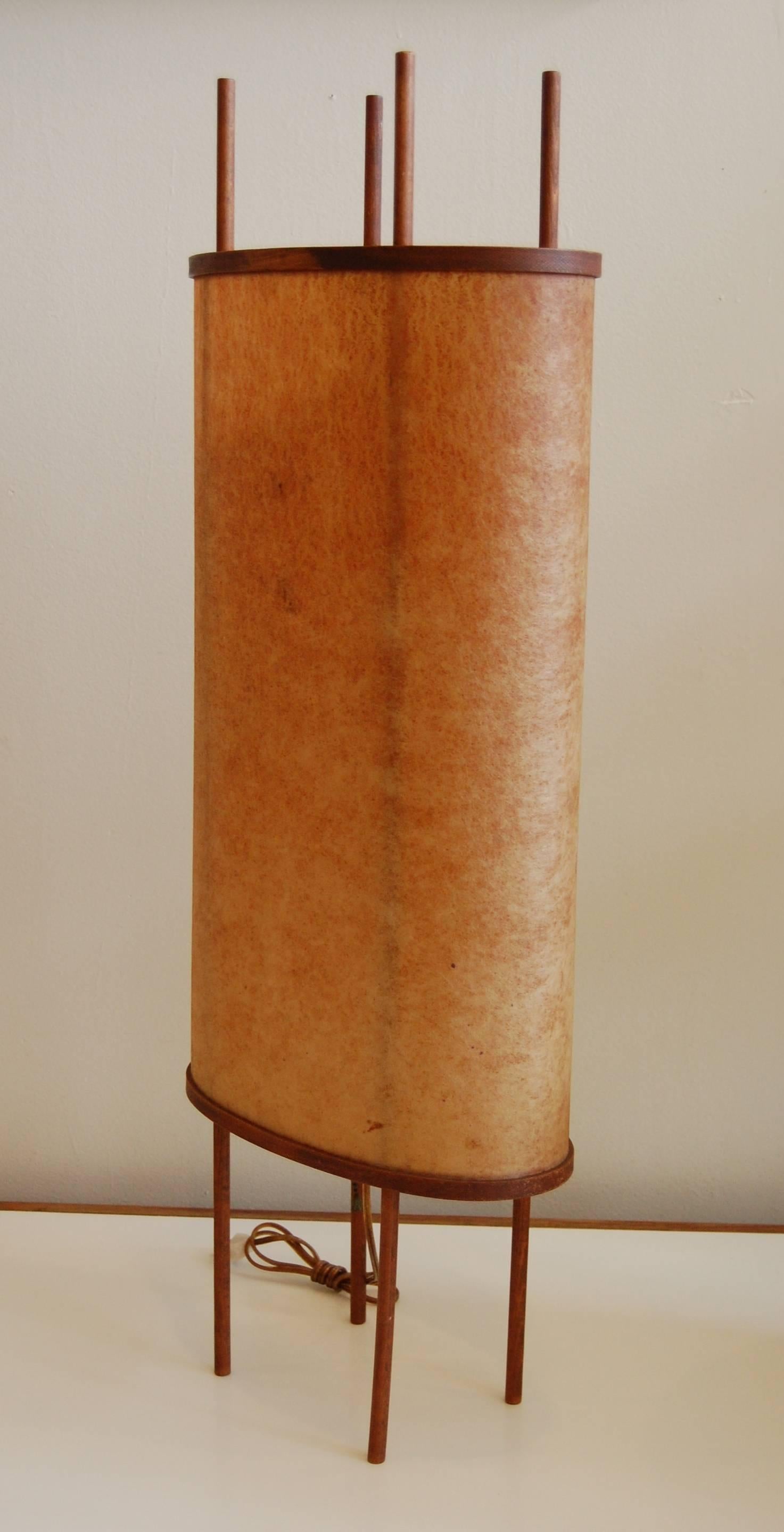 Four-legged Japanese table lamp, circa mid-late 1950s. An all original condition piece with a earthen colored parchment shade attached via steamed bentwood frames to four spindle legs. An interesting design with a high level of construction.