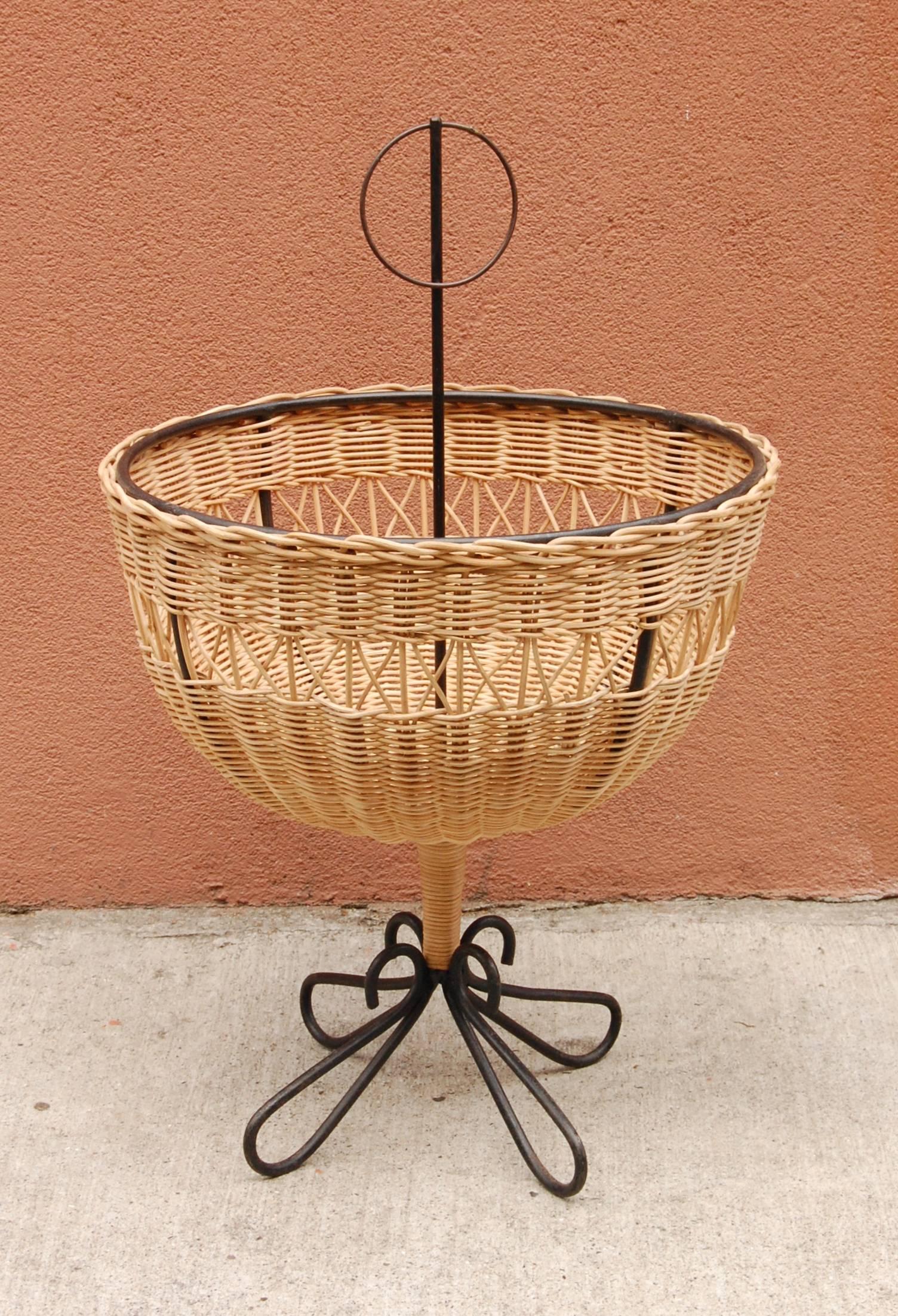 Handcrafted iron and wicker fruit basket from the 1960s, sculptural iron work to the feet having graceful curves. The wicker is in perfect condition without any breaks to it or other damage. A striking centerpiece for the dining or entry table.