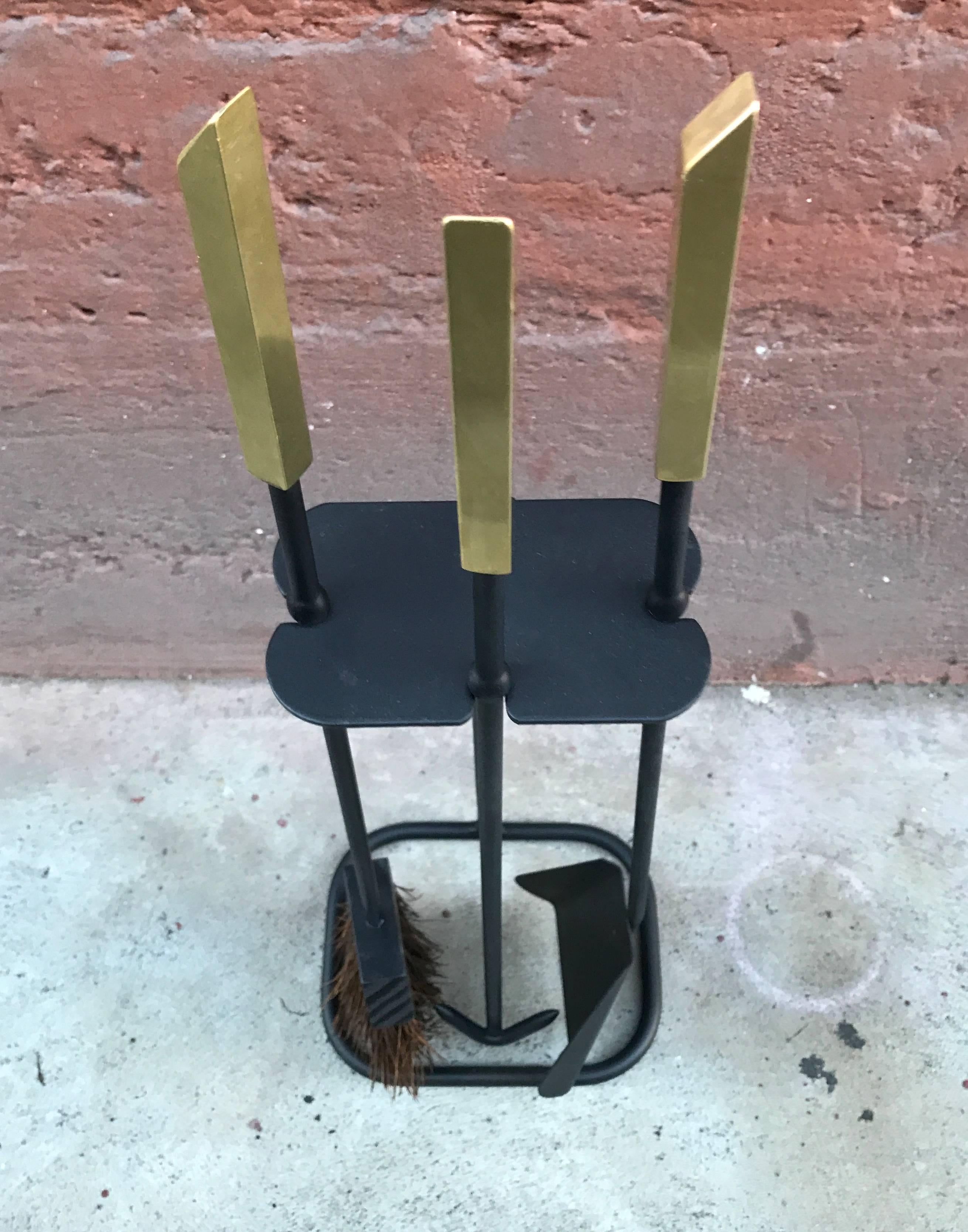 Freshly painted wrought iron fire tools with polished solid brass handles, a simple and striking modernist design.