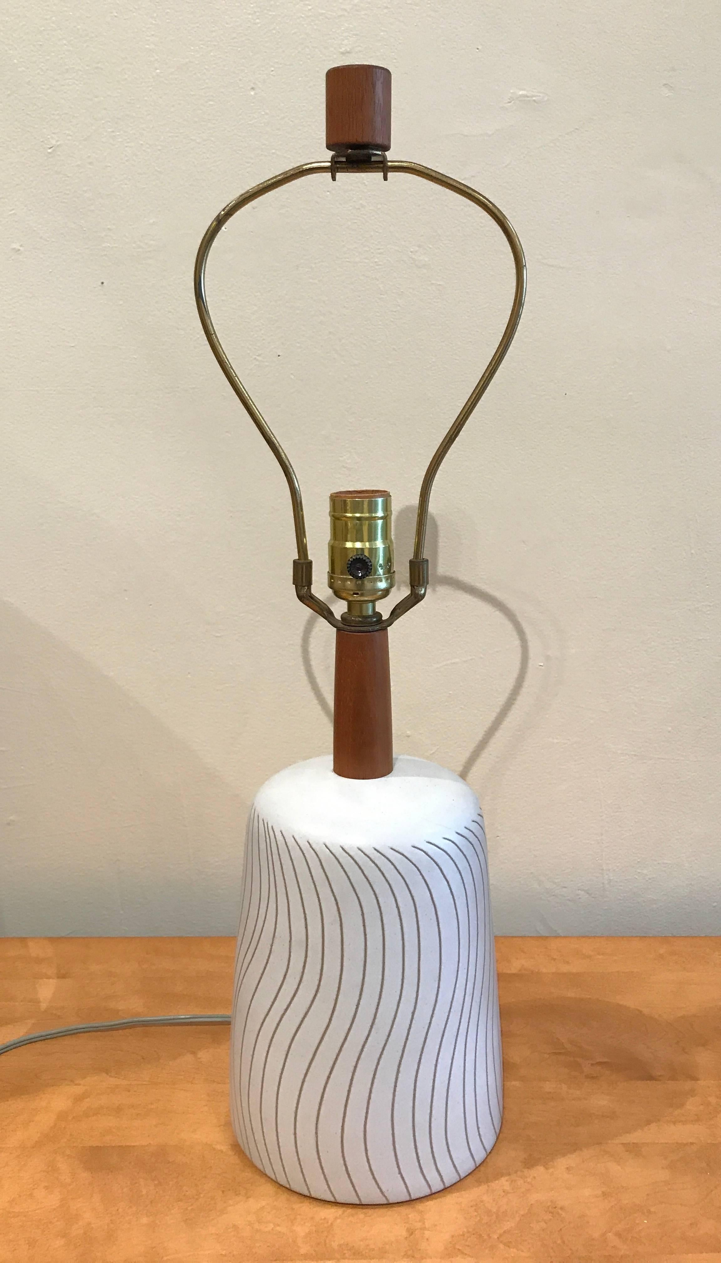 Small ceramic table lamp designed by Gordon and Jane Martz for their company Marshall Studios, circa late 1950s-early 1960s. Having a off-white glaze with brown incising wave patterns from the underlining clay body color, the finial and neck stem
