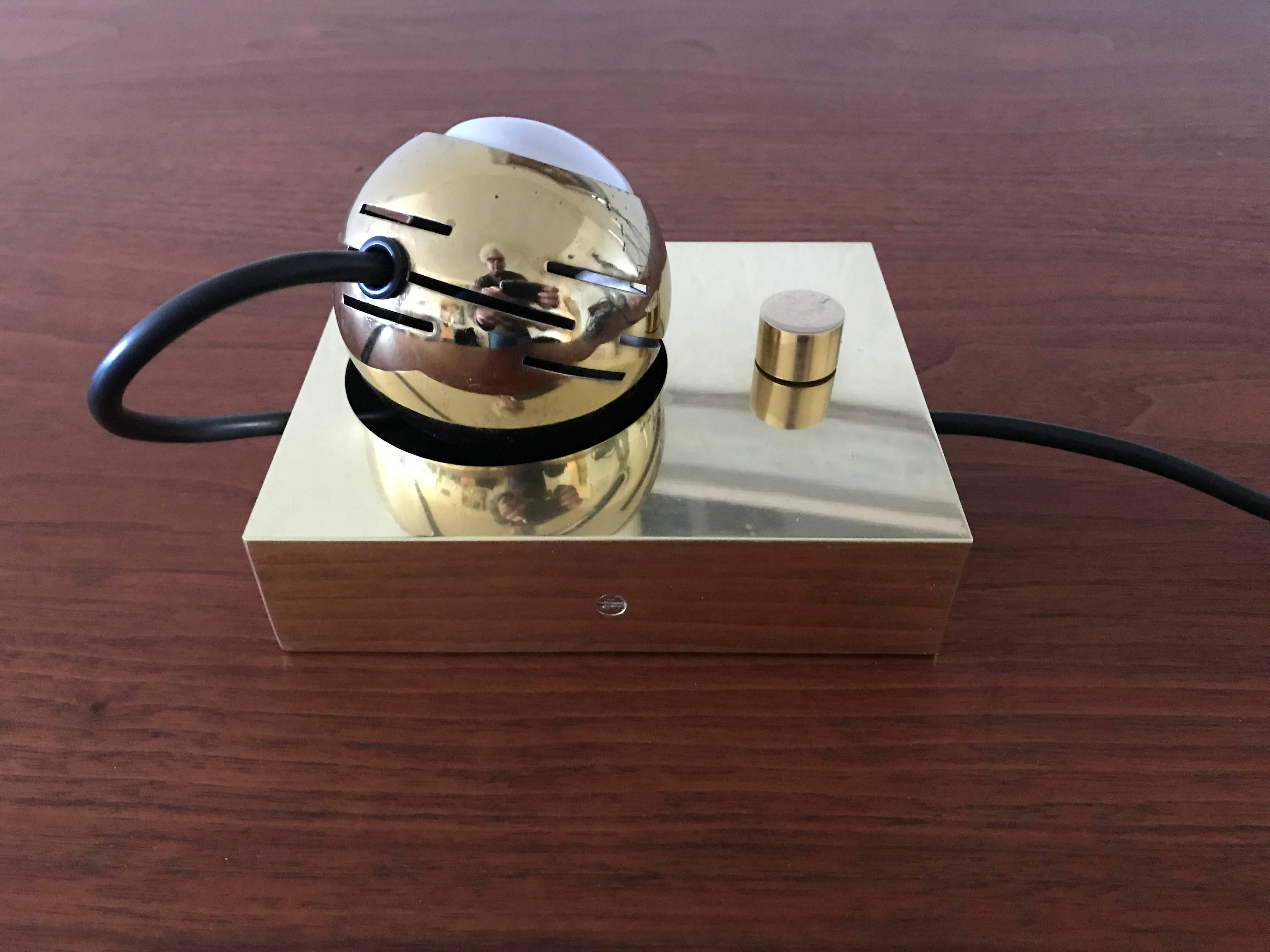 Arredoluce Eyeball made by Arredoluce of Italy and designed by Angelo Lelli. Solid brass body with a cylindrical brass dimmer switch, the brass-plated "eyeball" is held by a magnetic base which allows the user many adjustment options for