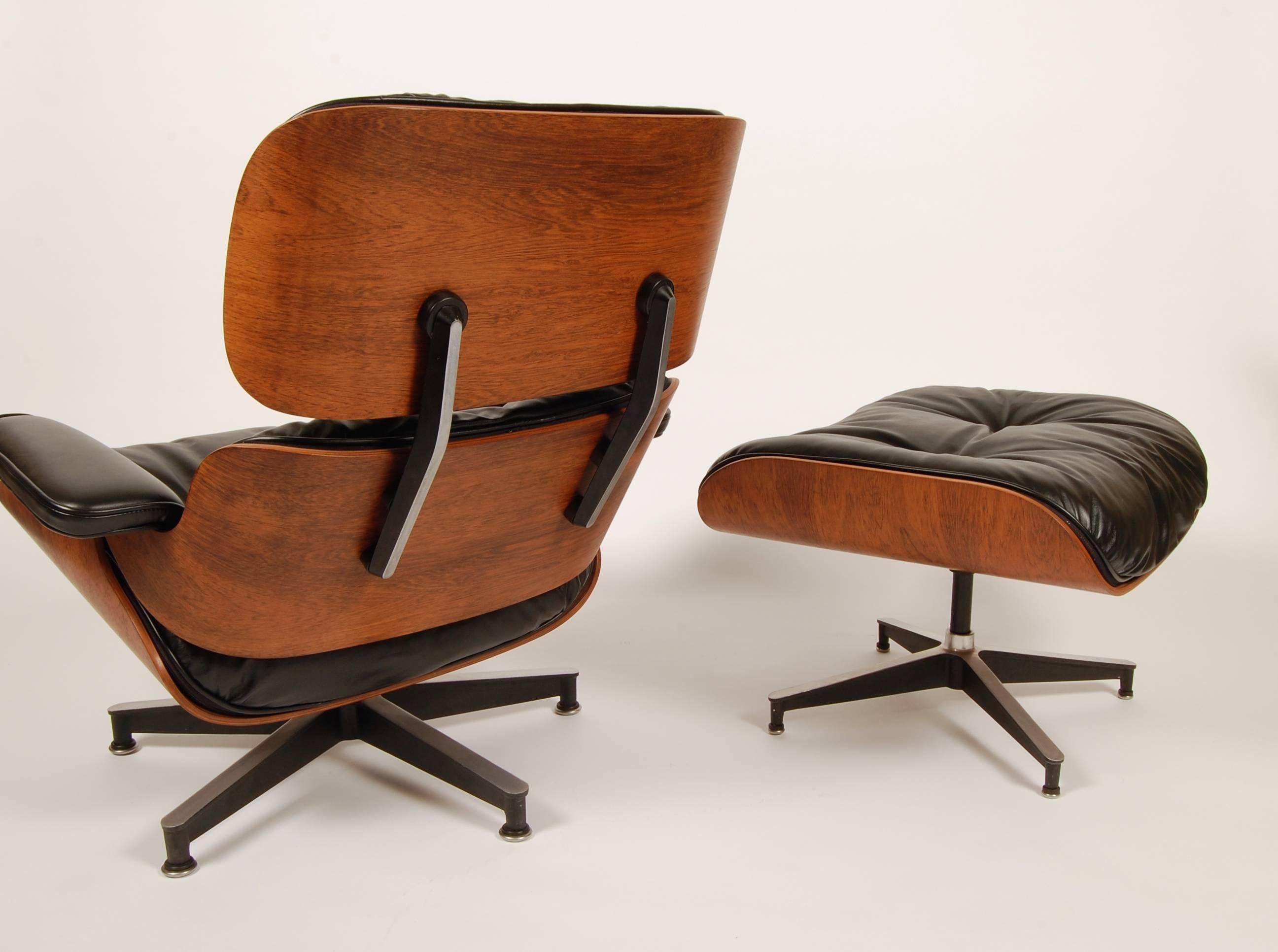 1960s production iconic Eames rosewood lounge and ottoman. Freshly conserved Brazilian rosewood shells and newly upholstered in period correct and quality black leather with the down, feather and latex cushions. Both lounge and ottoman retain the
