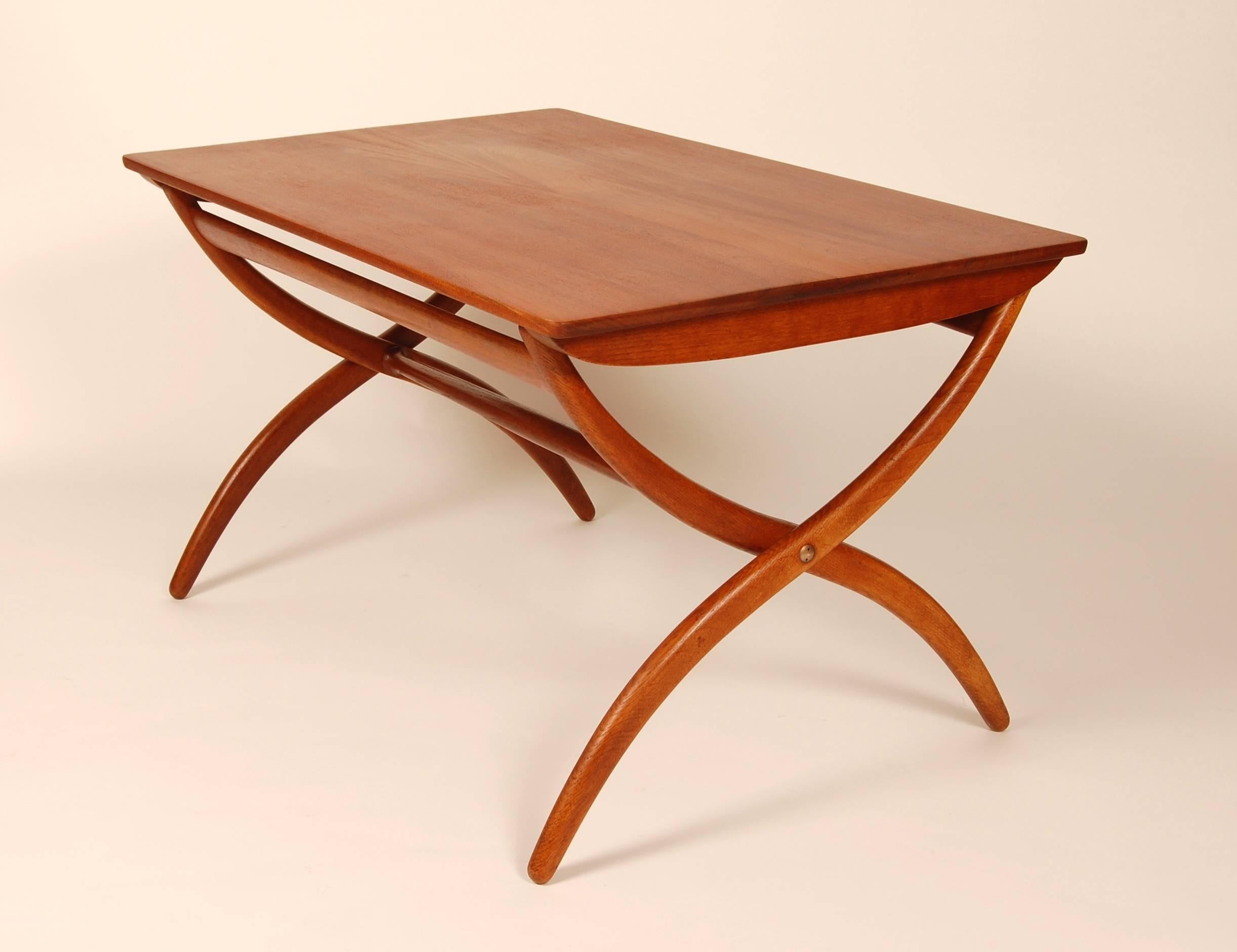 Adjustable coffee table designed by Ole Wanscher and crafted by Rud. Rasmussen Snedkerier circa 1951. Oil and wax finish solid teak top with oak legs and brass hardware. The table can adjust from 23