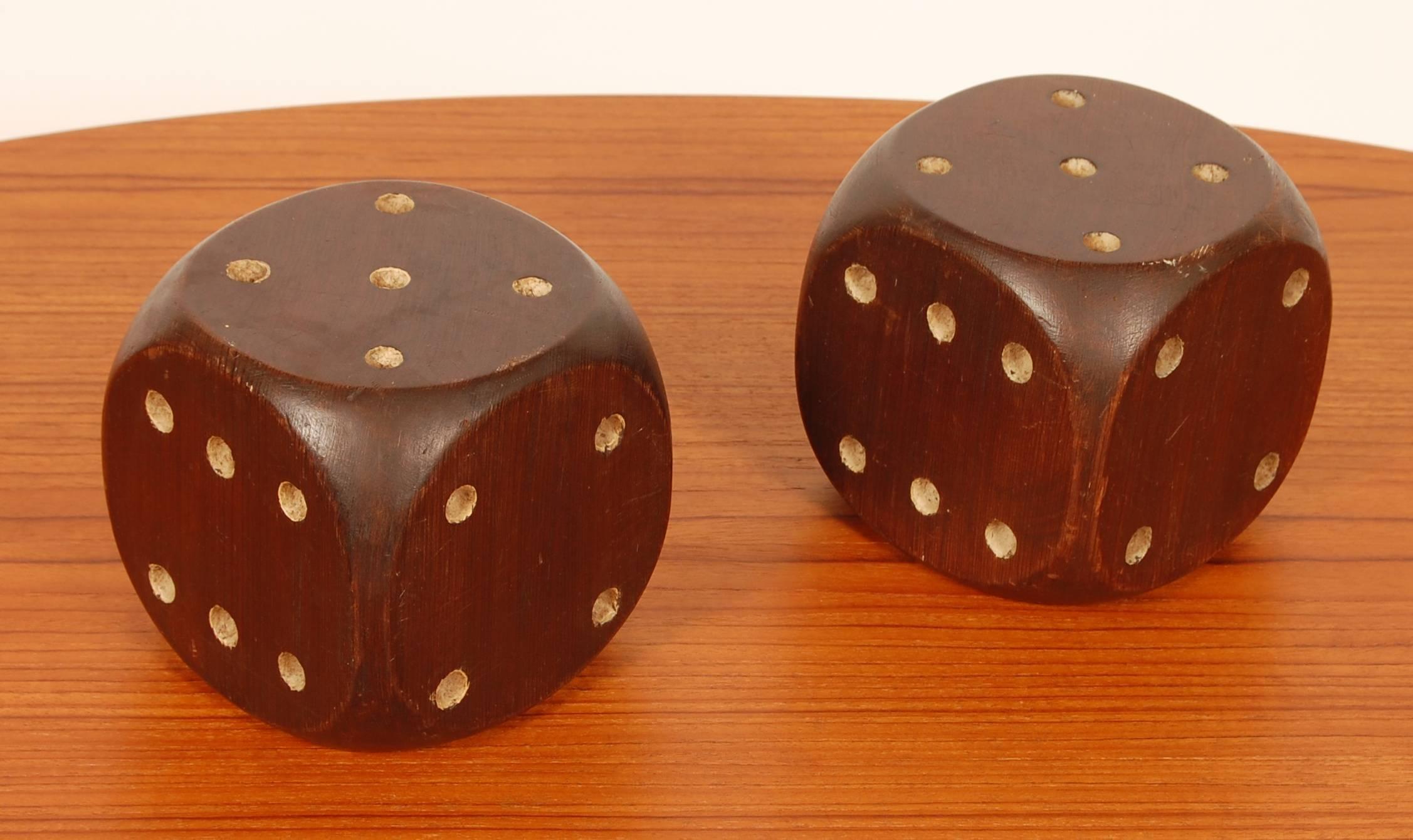 Large handmade wooden dice with a Folk Art sensibility. Crafted out of solid blocks of pine then stained and painted with a nice overall patina to the surfaces. Can be used either as bookends or as a decorative objects because of their scale.