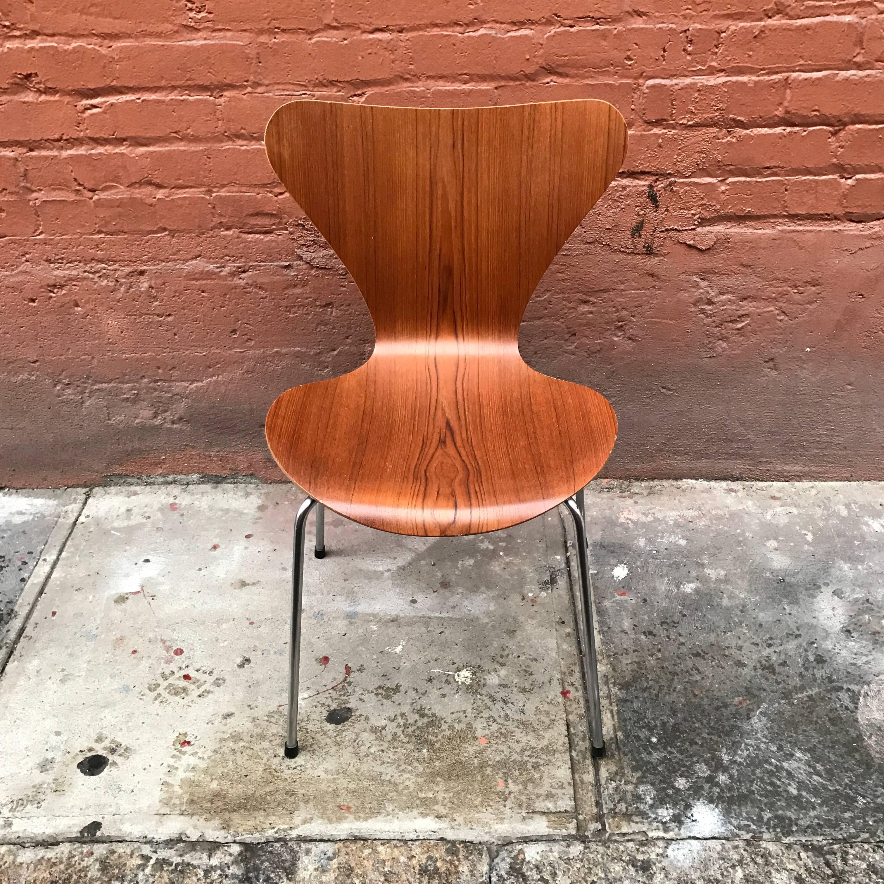 Arne Jacobsen teak series seven side chair, designed in 1955, this is a 1960s vintage model. It's uses a technique through which plywood is bent in three dimensions. The base is a satin chrome with four legs. The teak has a very fugitive grain.