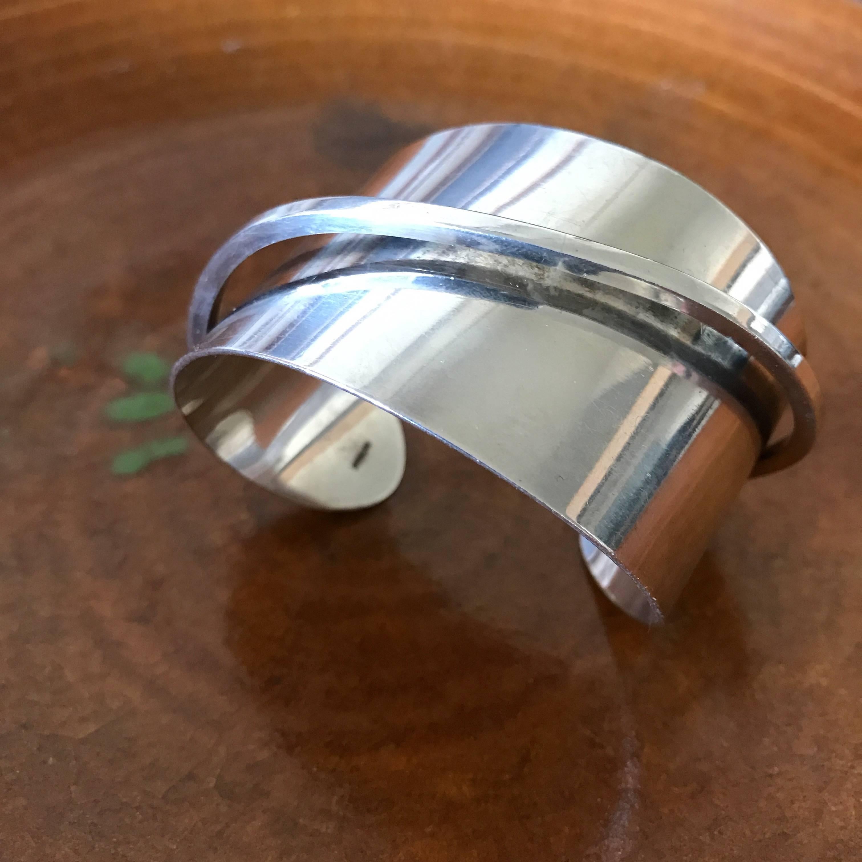 Henry Steig (1906-1973) abstract modernist sterling silver asymmetrical cuff with a sweeping embellishment running across the top. It's circumference is 6.25