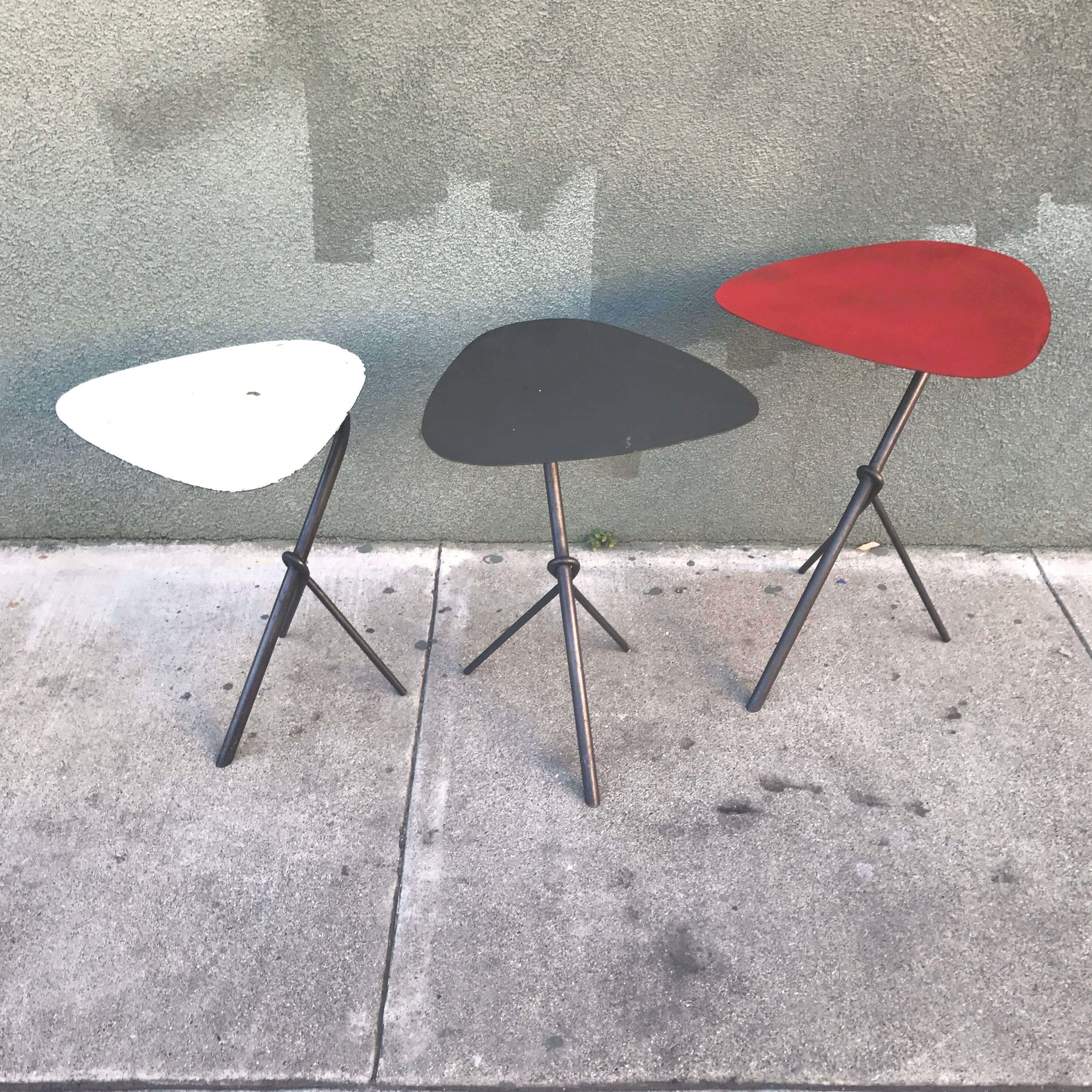 Three unusual French, circa 1950s nesting tables in white, slate black and red, the shapes are reminiscent of Alexander Calder's art work in form and color. The bases are a tripod configuration with an interesting wraparound leg design at the focal