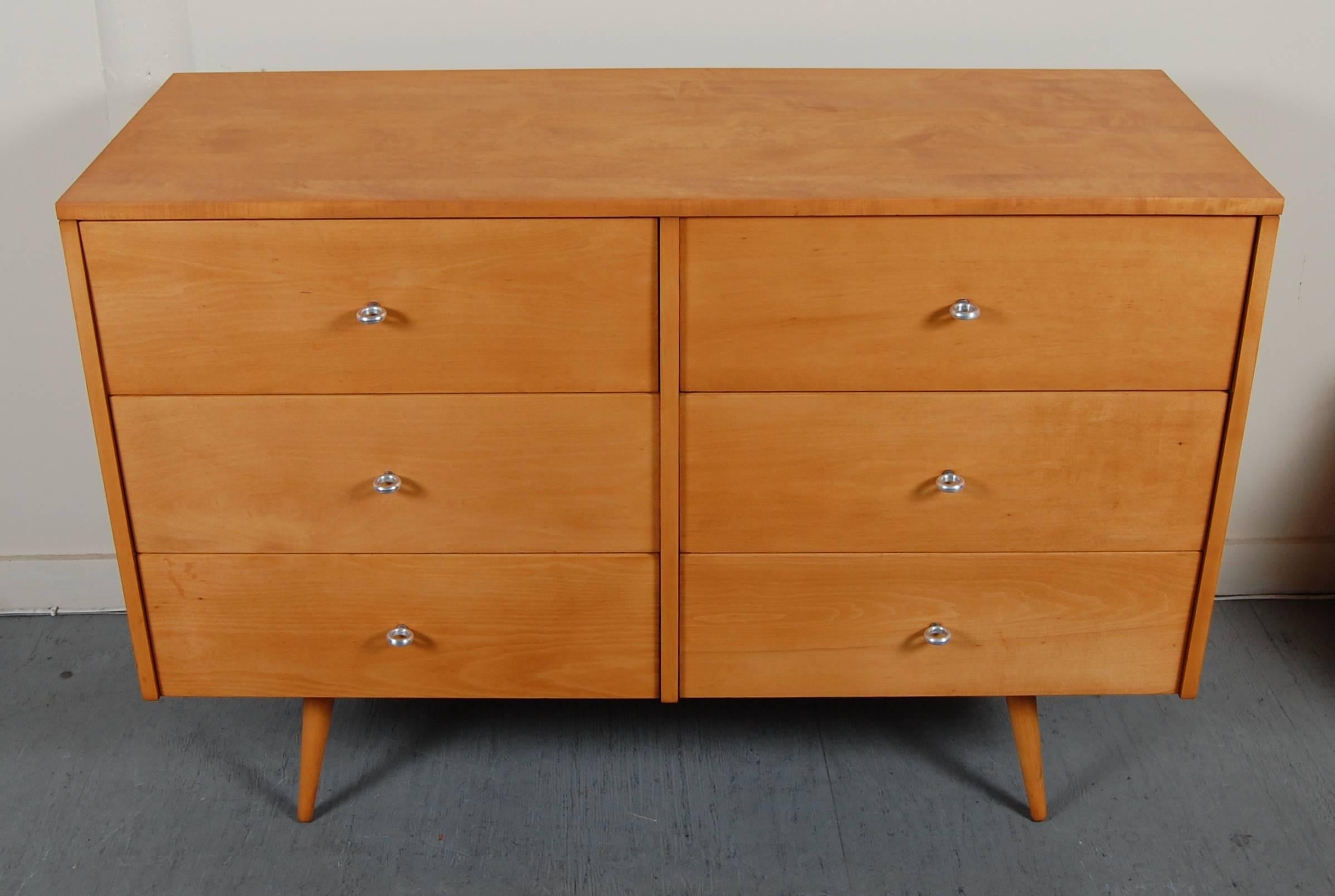 Compact dresser by Paul McCobb for his Planner Group line. Six drawers with aluminum ring pulls and splayed conical legs, the inside top drawer has the McCobb brand mark. Tastefully restored, fresh with a vintage hue.