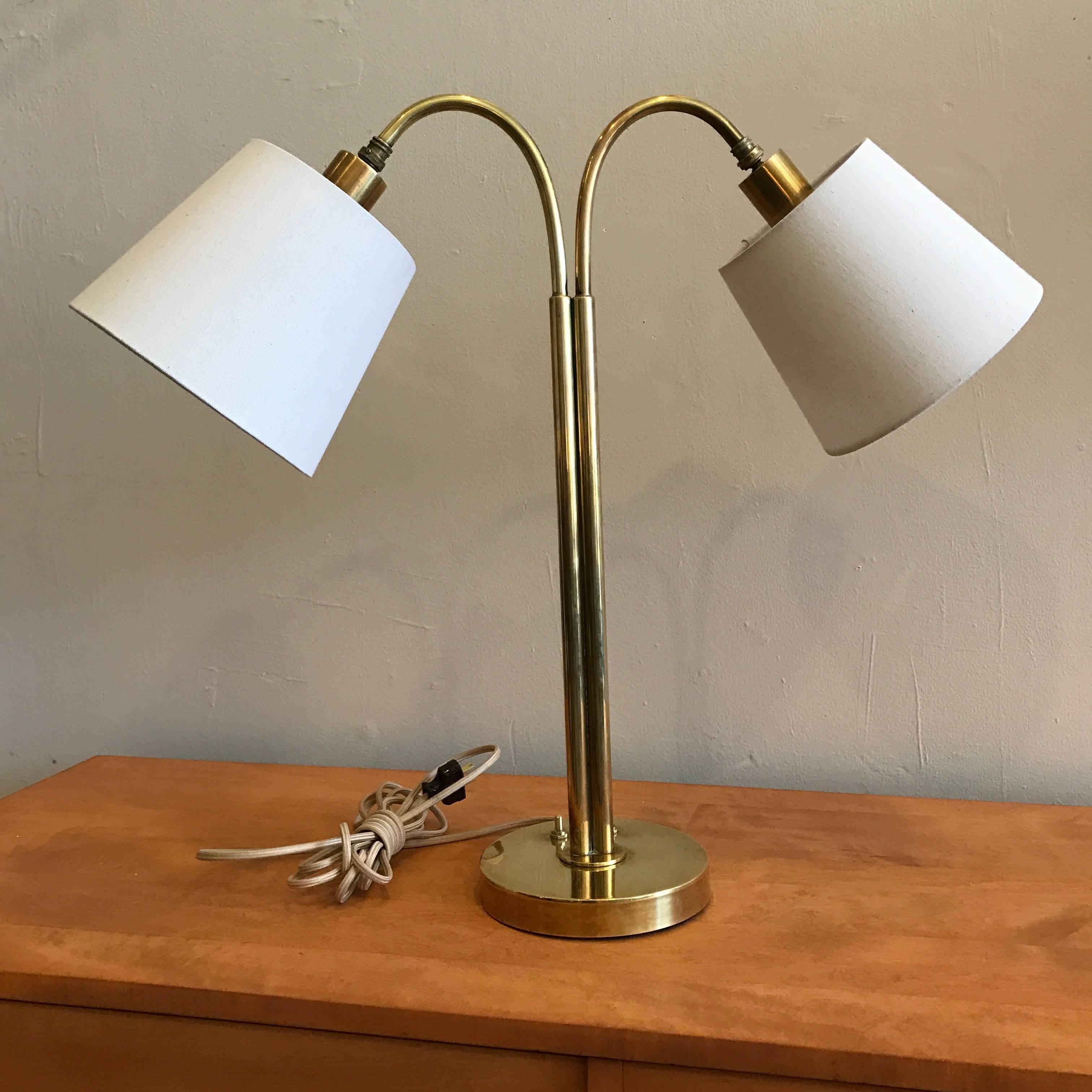 Handmade brass table lamp by California craftsman Norman Grag who's family spans generations in the crafts, his work was sold through Gumps of San Francisco. This solid brass two light table lamp has need custom linen shades and has been fully