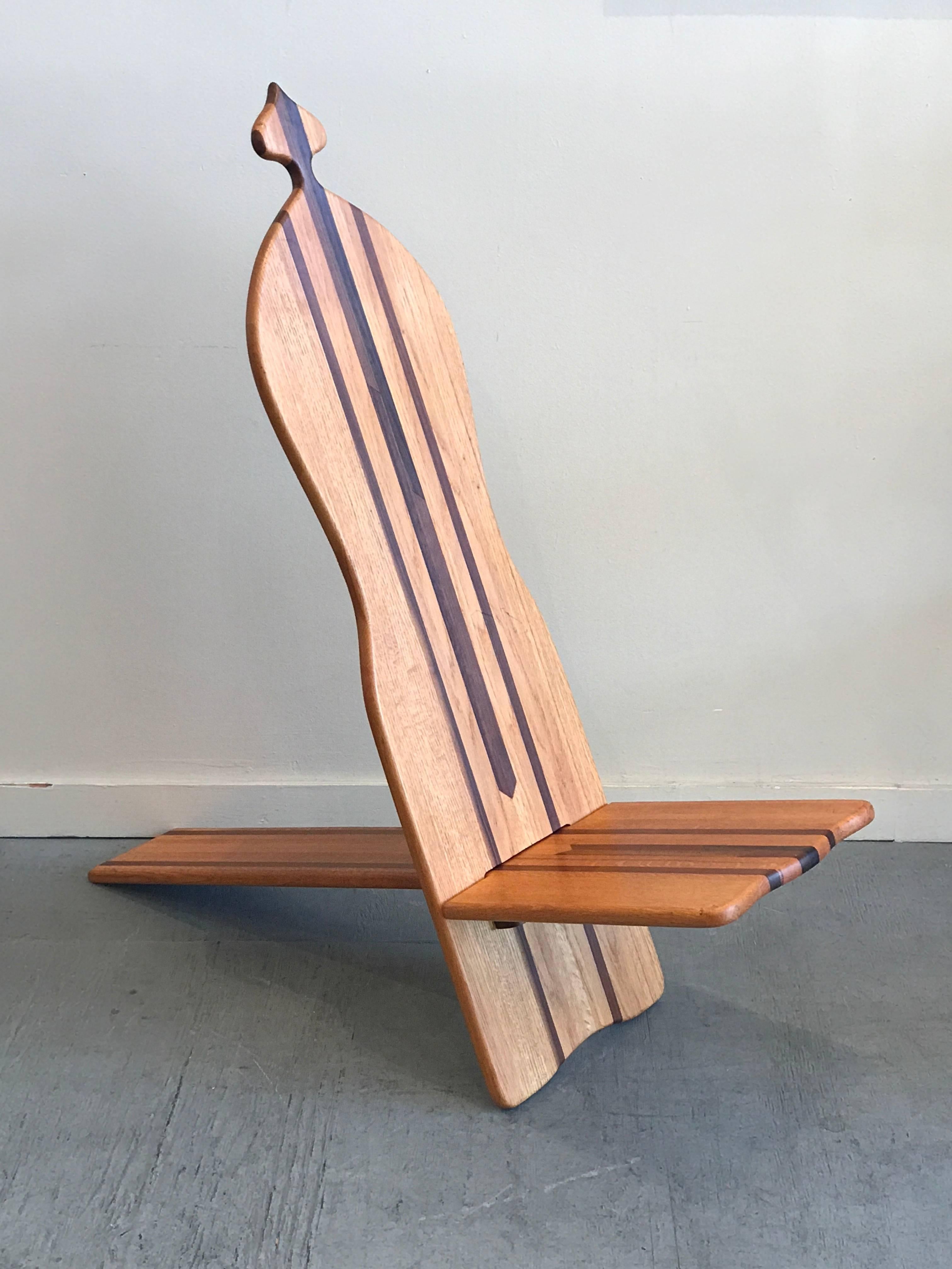 Constructed of solid oak, cherry and walnut is this studio made Baluba "Chief's" chair, designed to come apart the chair consists of two pieces that fit into one another. A 1970s take on a ancient design from Africa, the darker woods