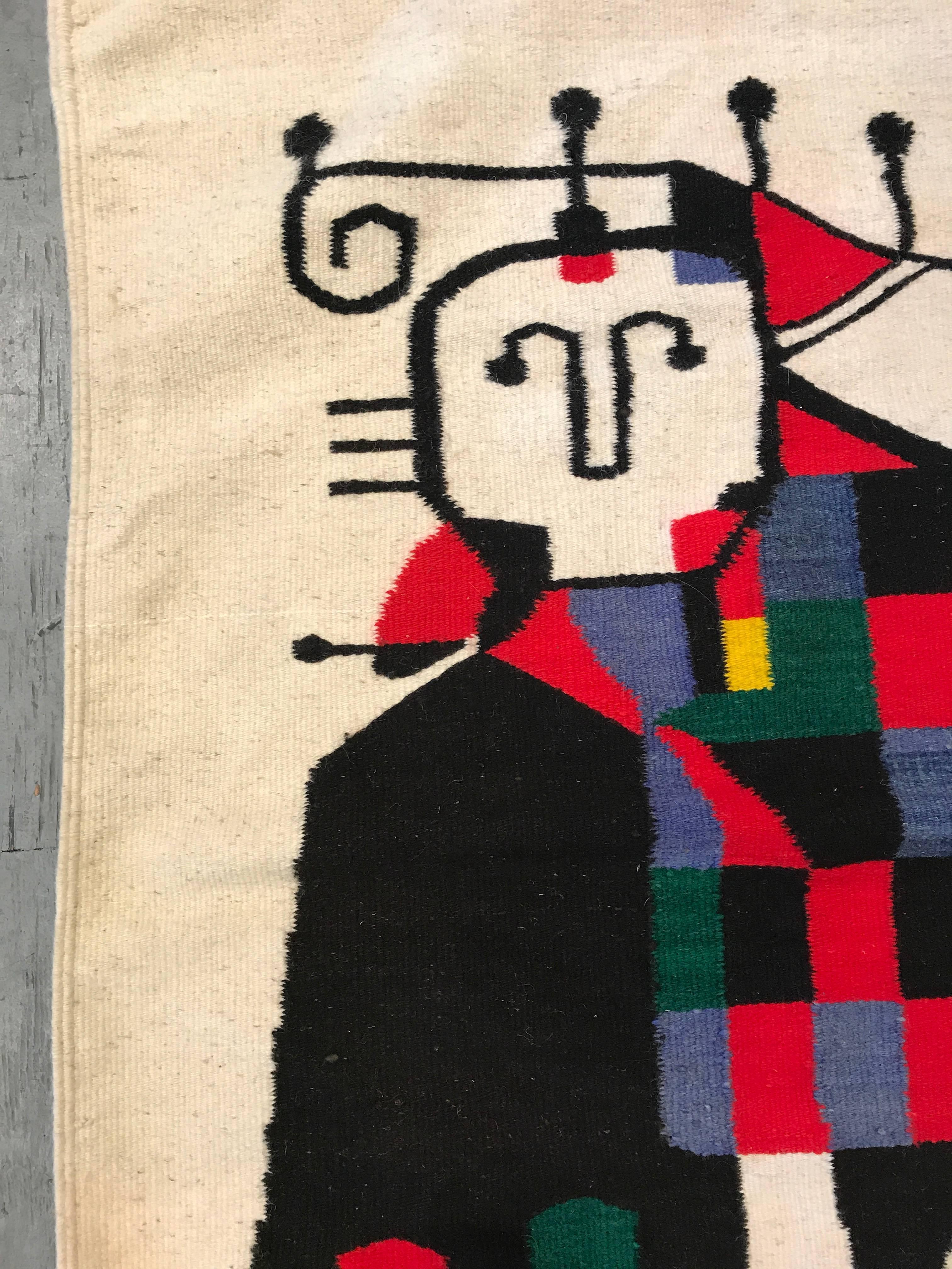 Wall tapestry done in the manner of Joan Miro, wool construction with abstract figures, in black, red, yellow and blue. Handcrafted in wool using natural dyes in its construction.