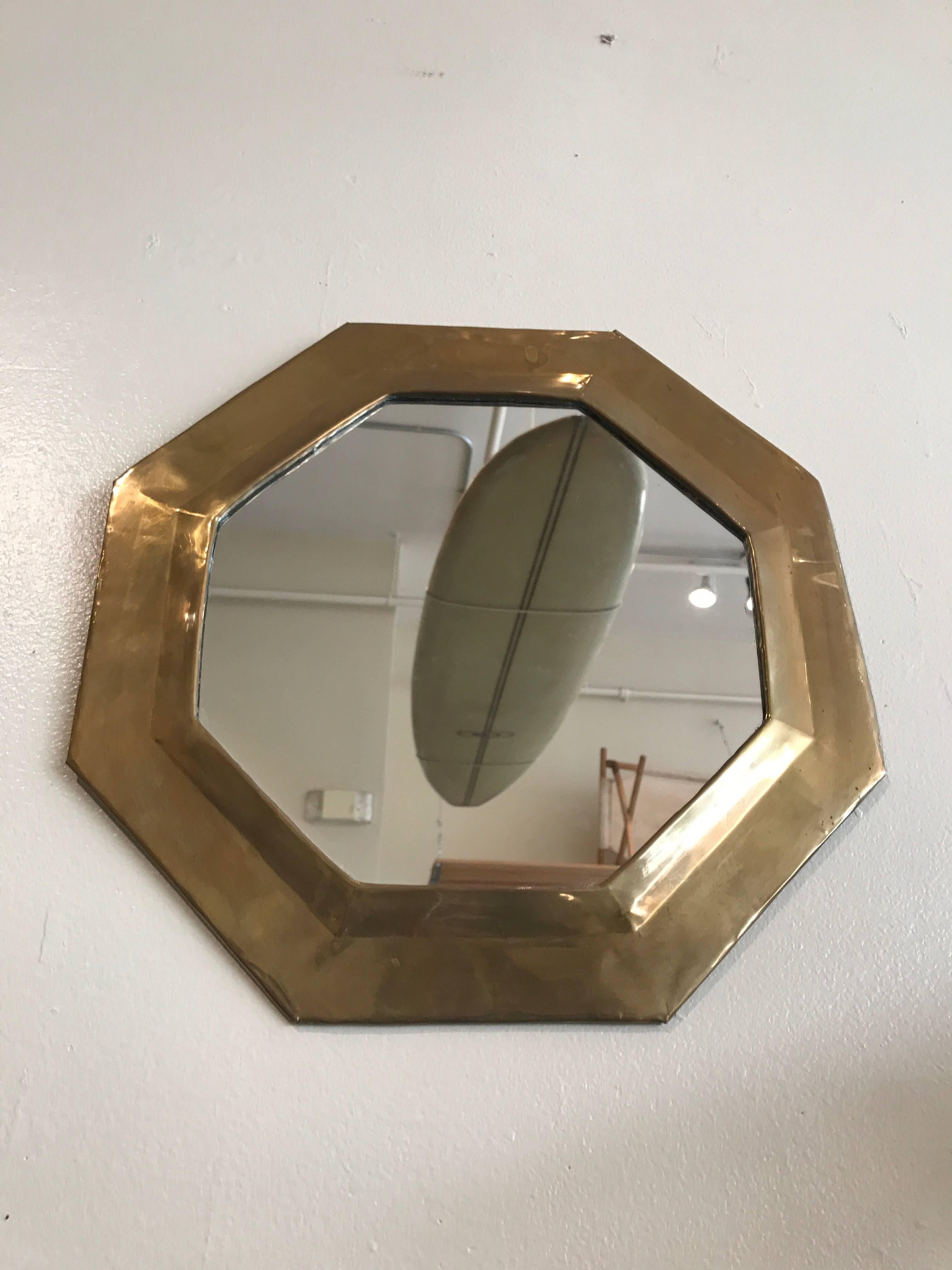 Solid brass octagonal mirror with raised edges towards the centre, nice accent piece.