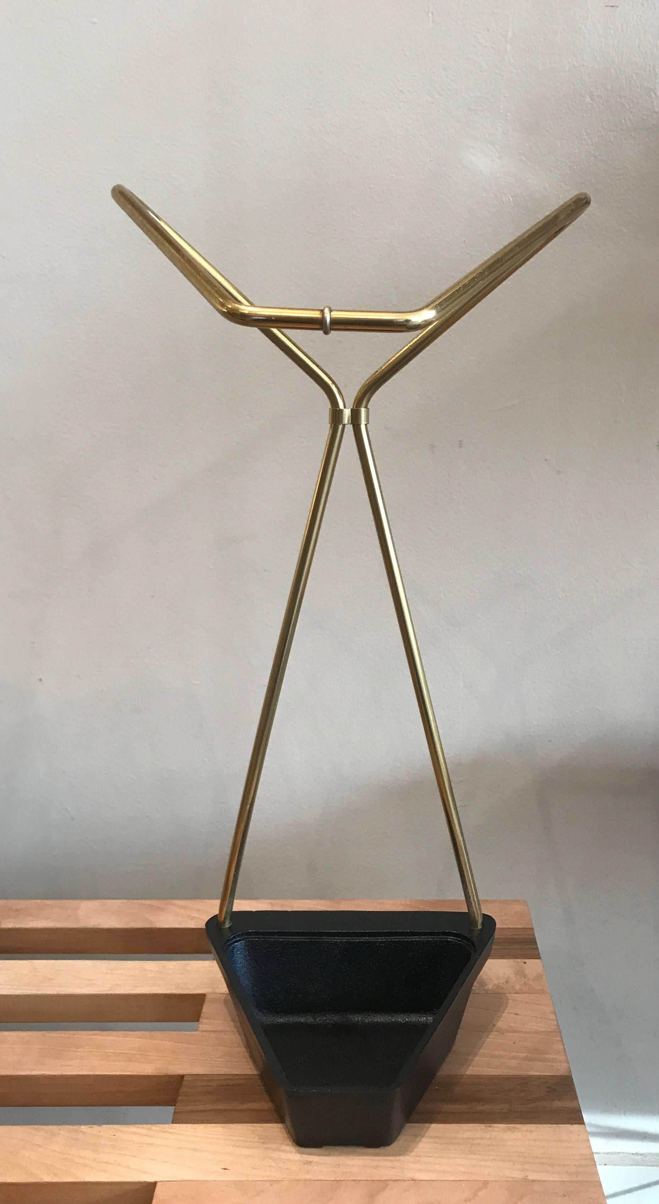 Ultra simple modernist umbrella stand in bent brass rod with a cast iron base.