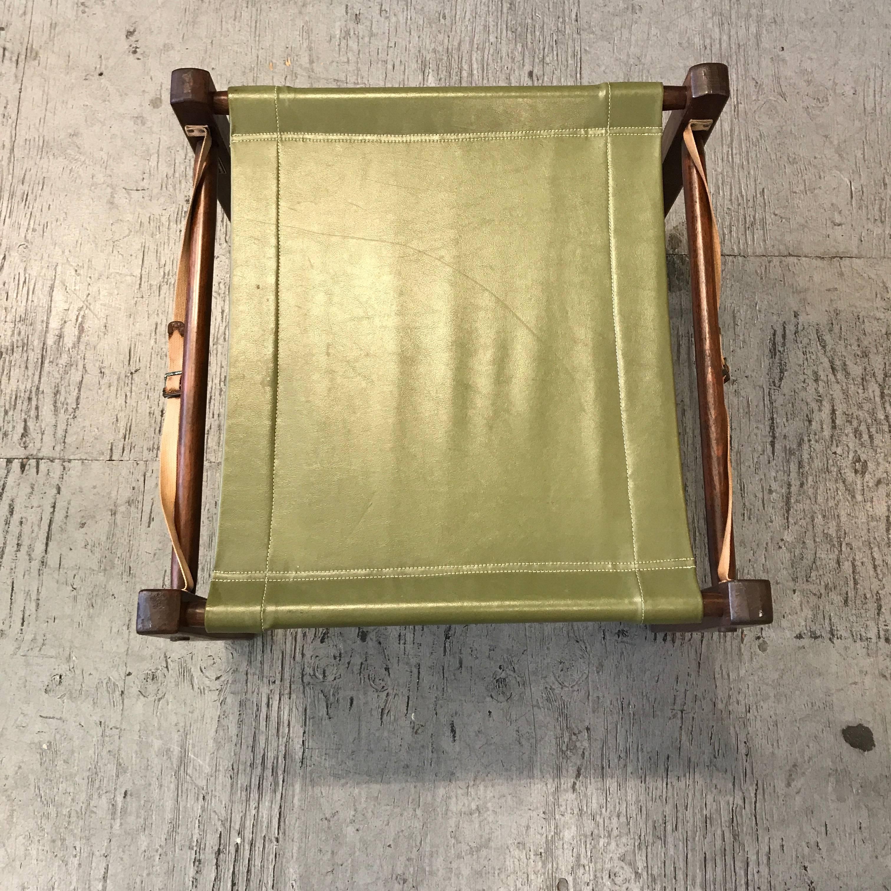 Break down camping / campaign ottoman by Gold Medal Folding Furniture, designed to come apart and roll up into a compact unit, green vinyl fabric cover and two canvas straps attached to the wooden frame.