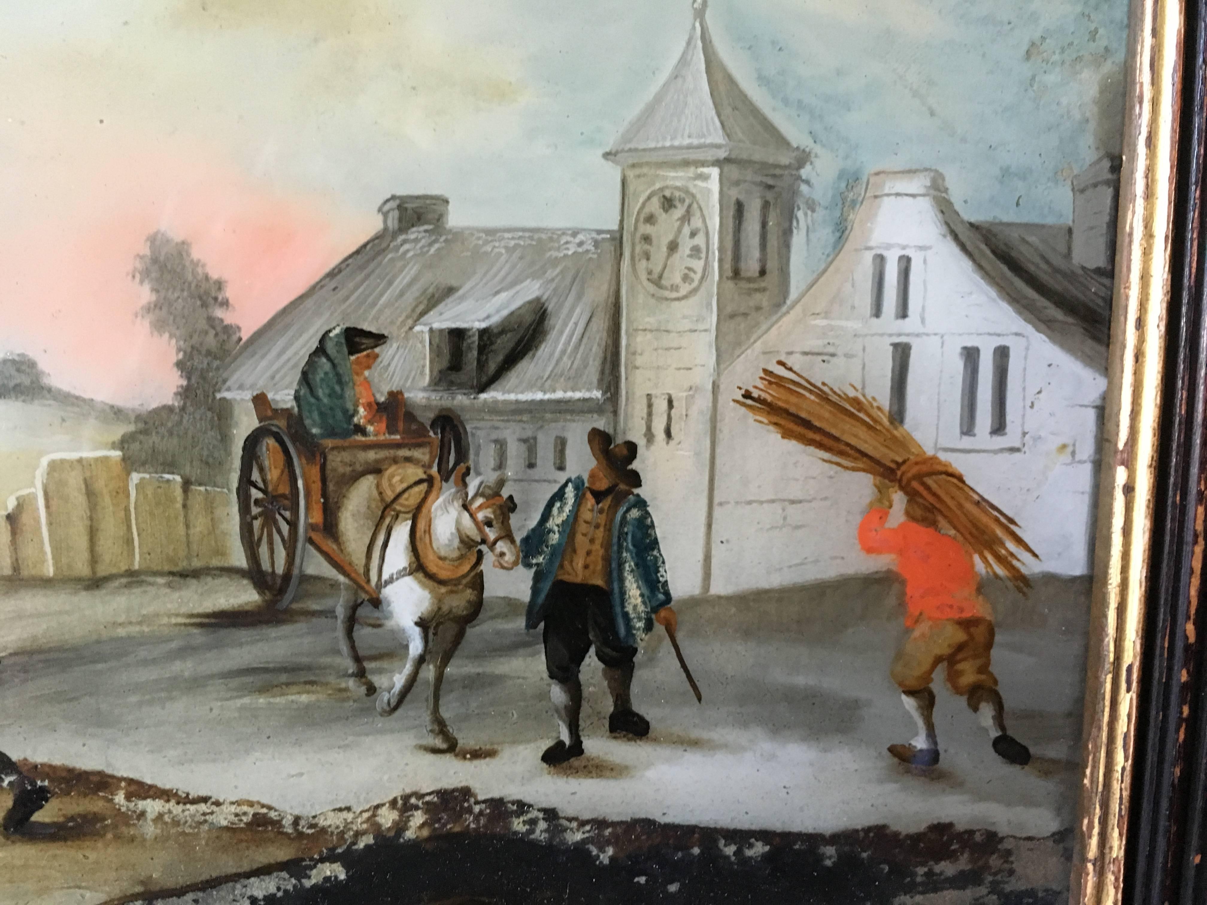 A charming églomisé painting (reverse painting on glass), circa 1800, in its original frame, depicting a village scene, probably French.