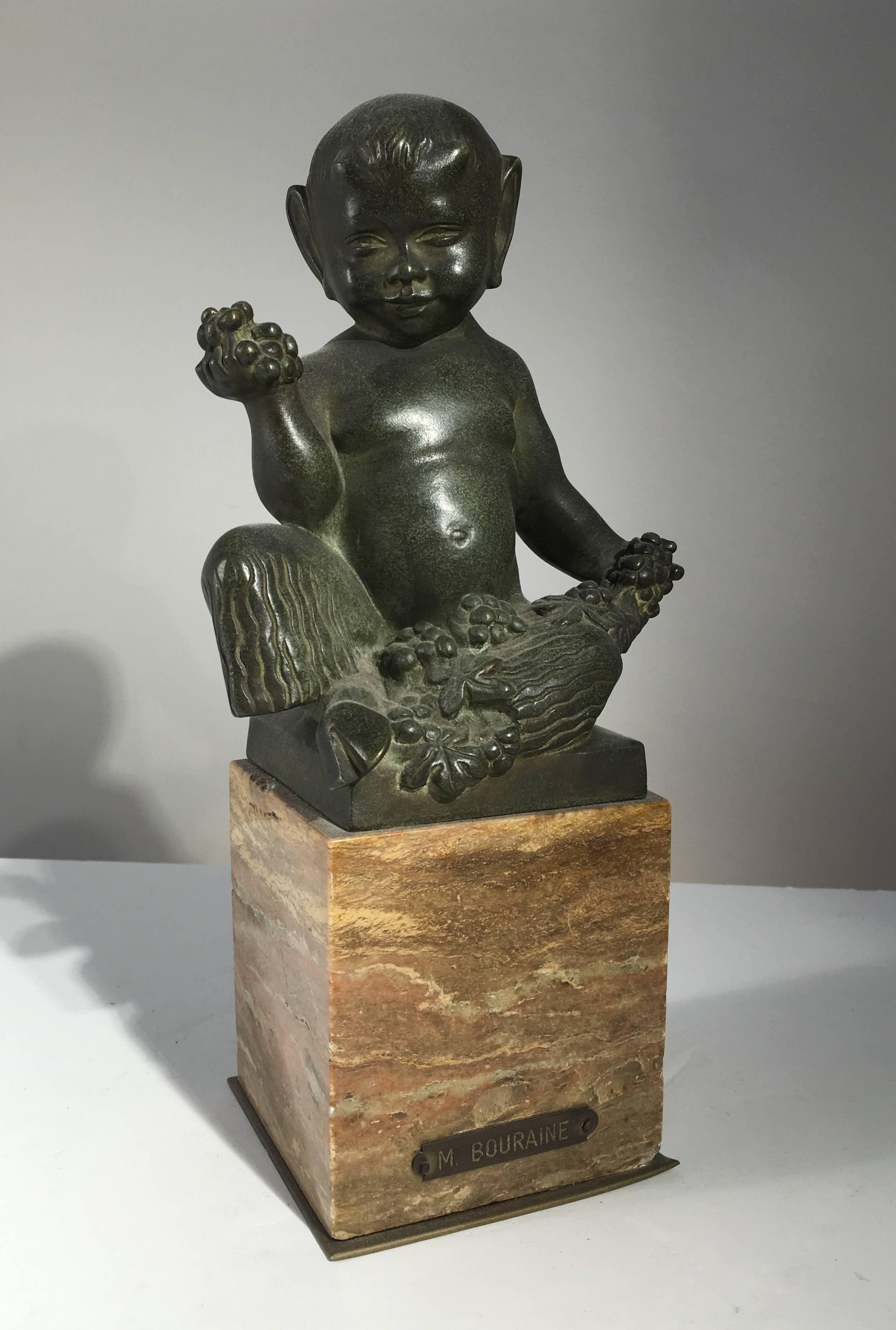 A charming bronze by Marcel Andre Bouraine, circa 1930, of a seated faun with grapes and flowers, beautiful patina and elegant marble base with brass name plaque. From the estate of Pierre Moulin, author of French Country style books and founder of
