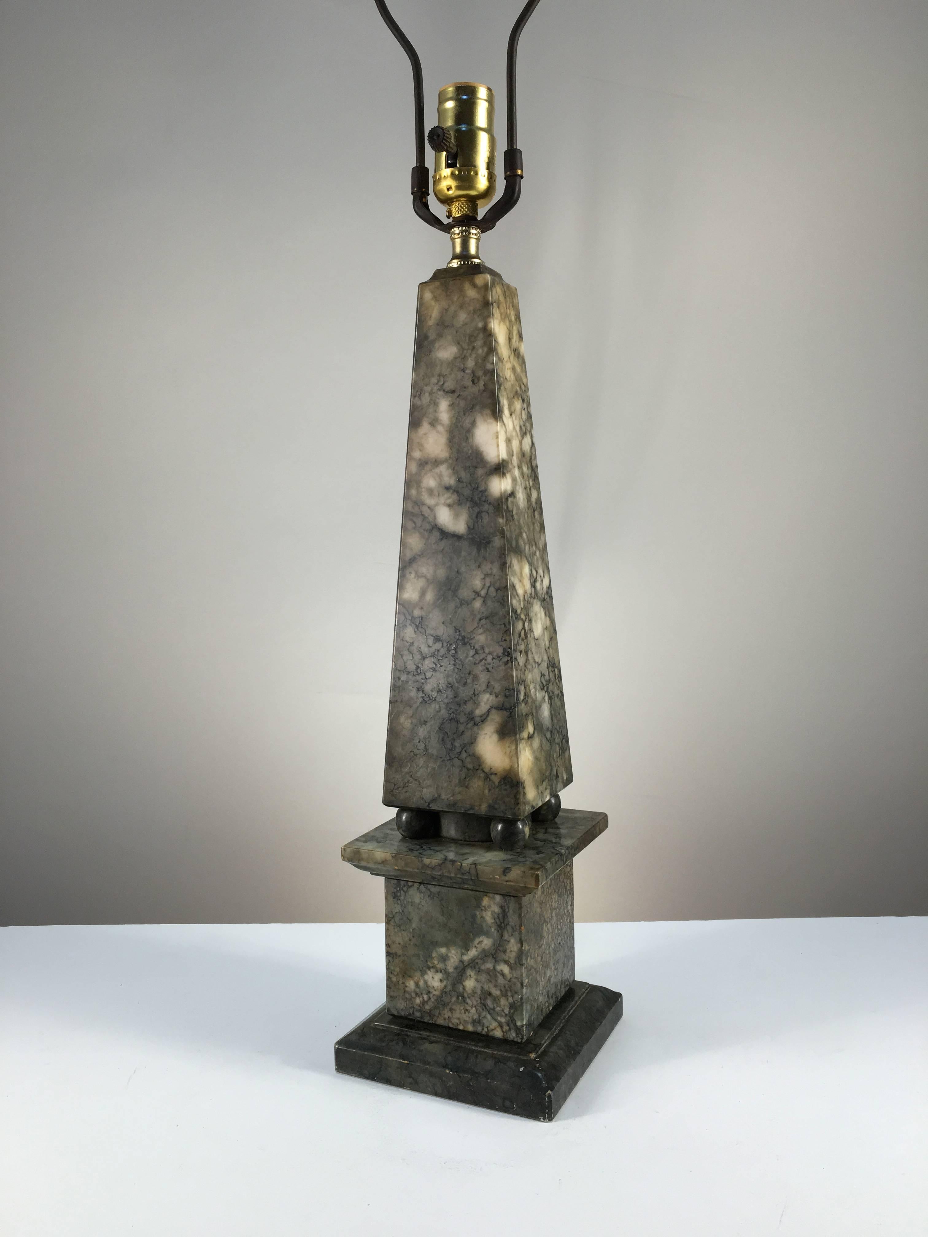 A chic obelisk-form table lamp in grey/moss marble, circa 1930. Measures: The height to top of obelisk is 20