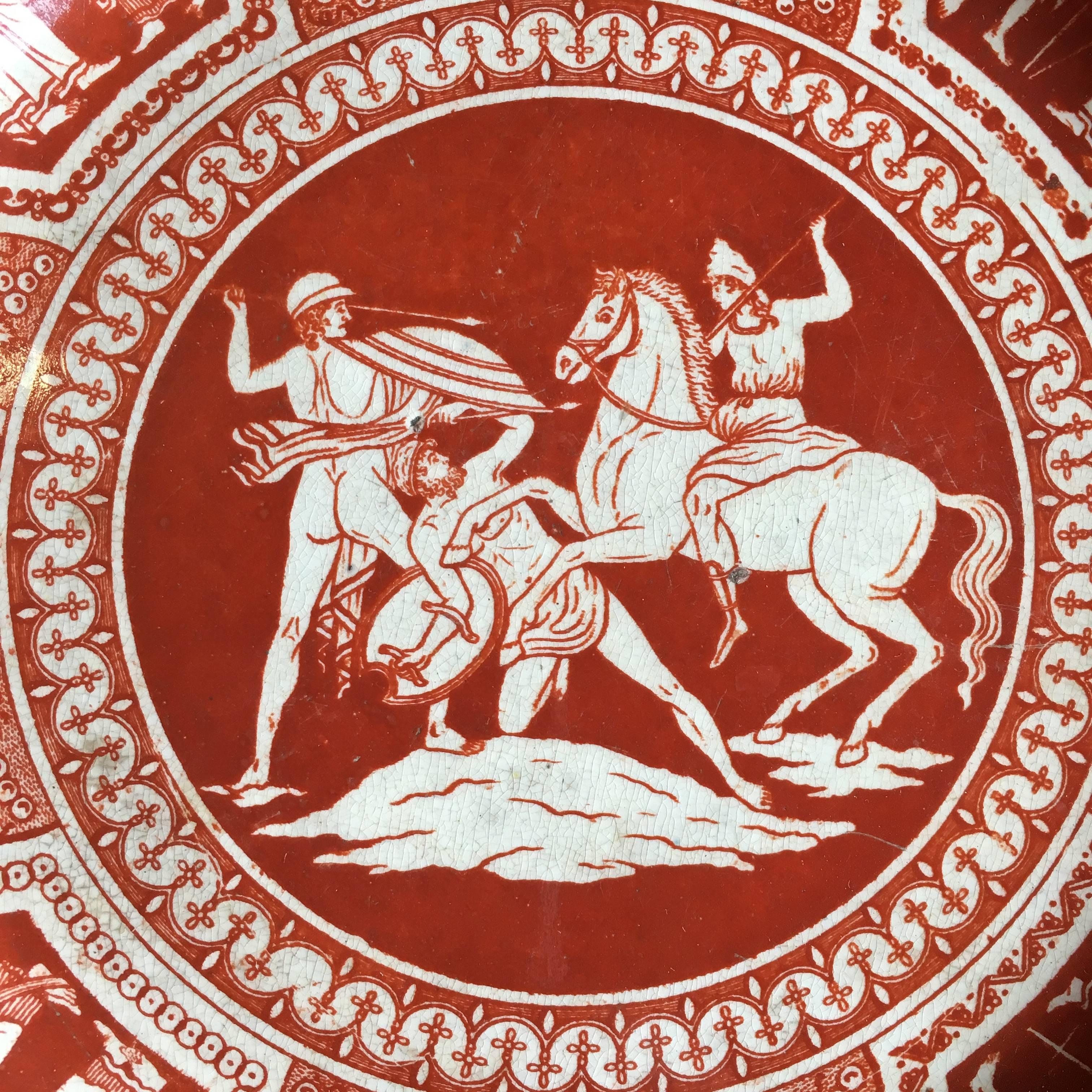 An interesting early 19th century plate decorated in coral red glaze depicting a Greek battle scene and other motifs, circa 1800, French.