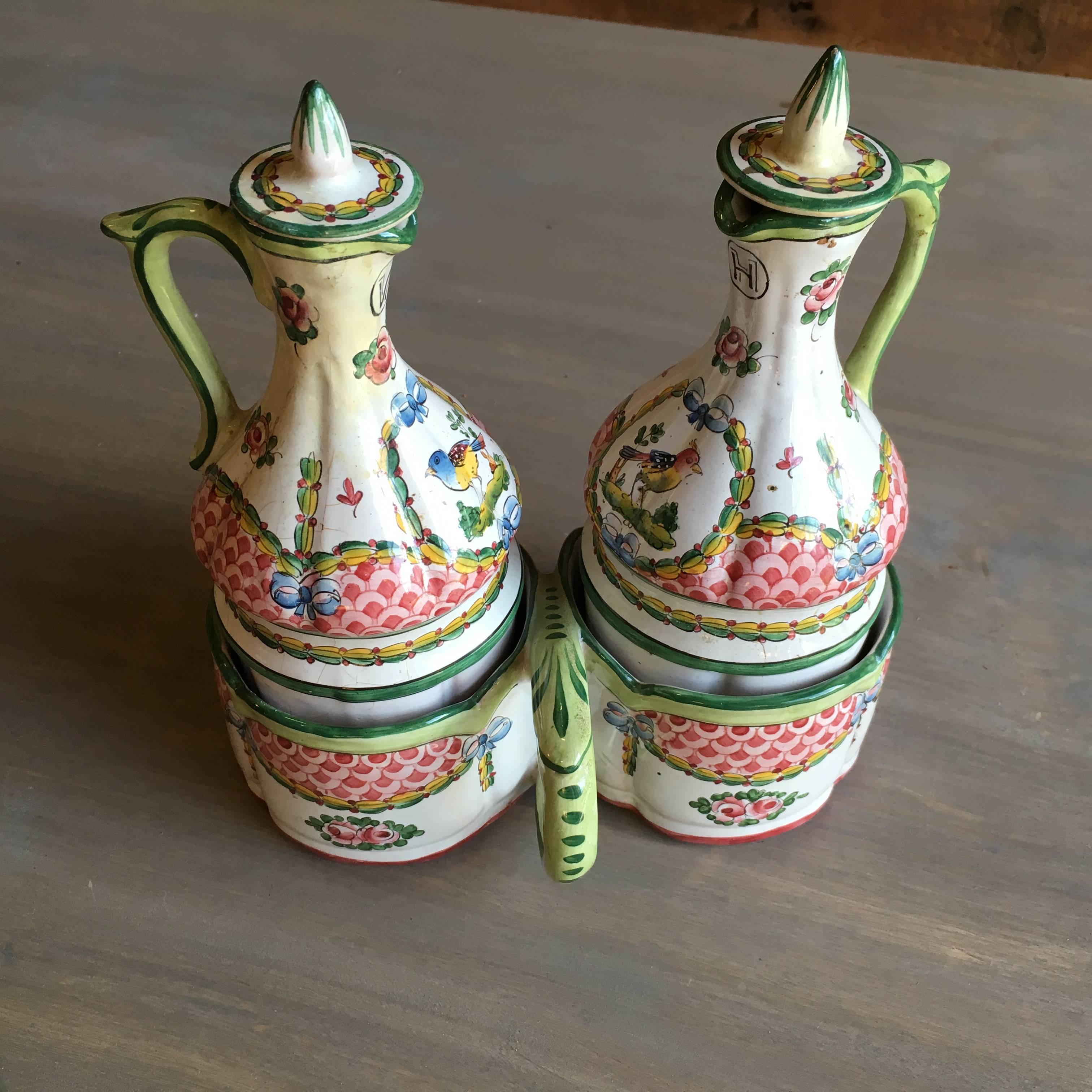 A charming 18th century French cruet set in faience, with original holder and stoppers, nicely decorated with birds, flowers and garlands with the H for Huile (oil) and the V for Vinaigre (vinegar). Signed on bottom 