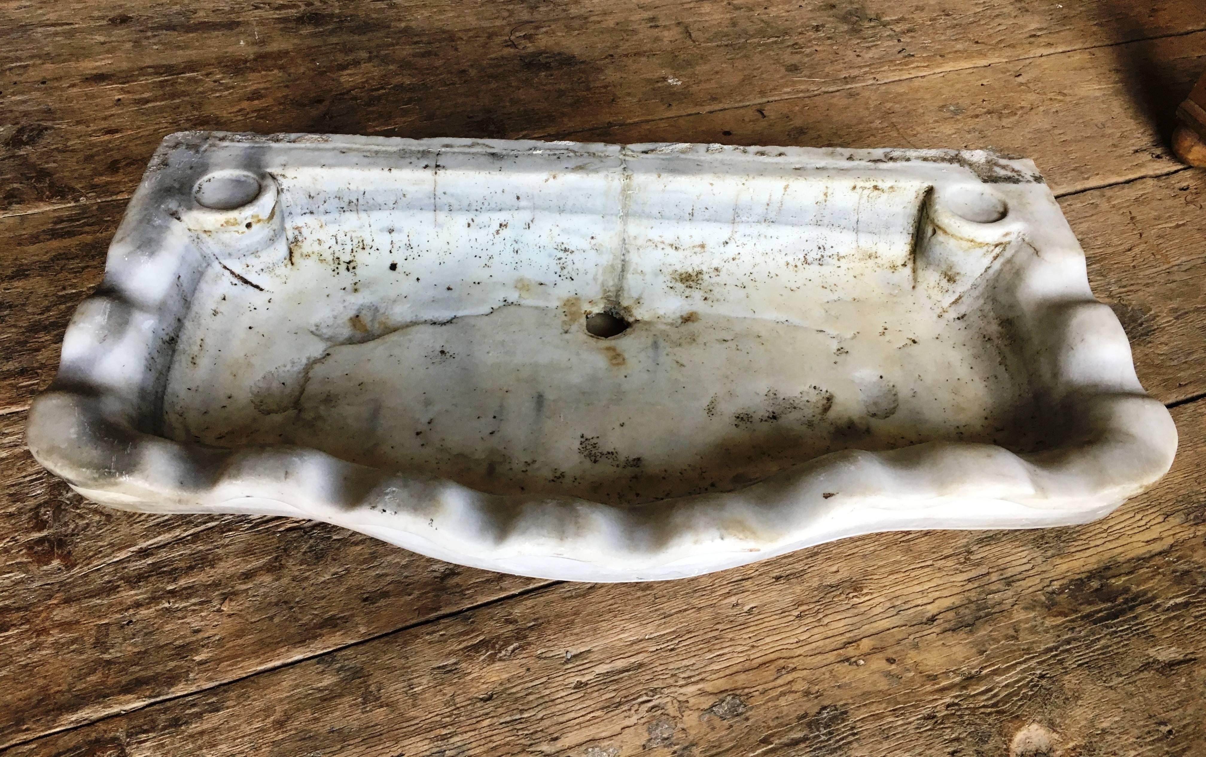 An 18th century Italian marble sink in shell-form, the front serpentine edge with undulating rim. From the estate of Amy Perlin. Lots of character.