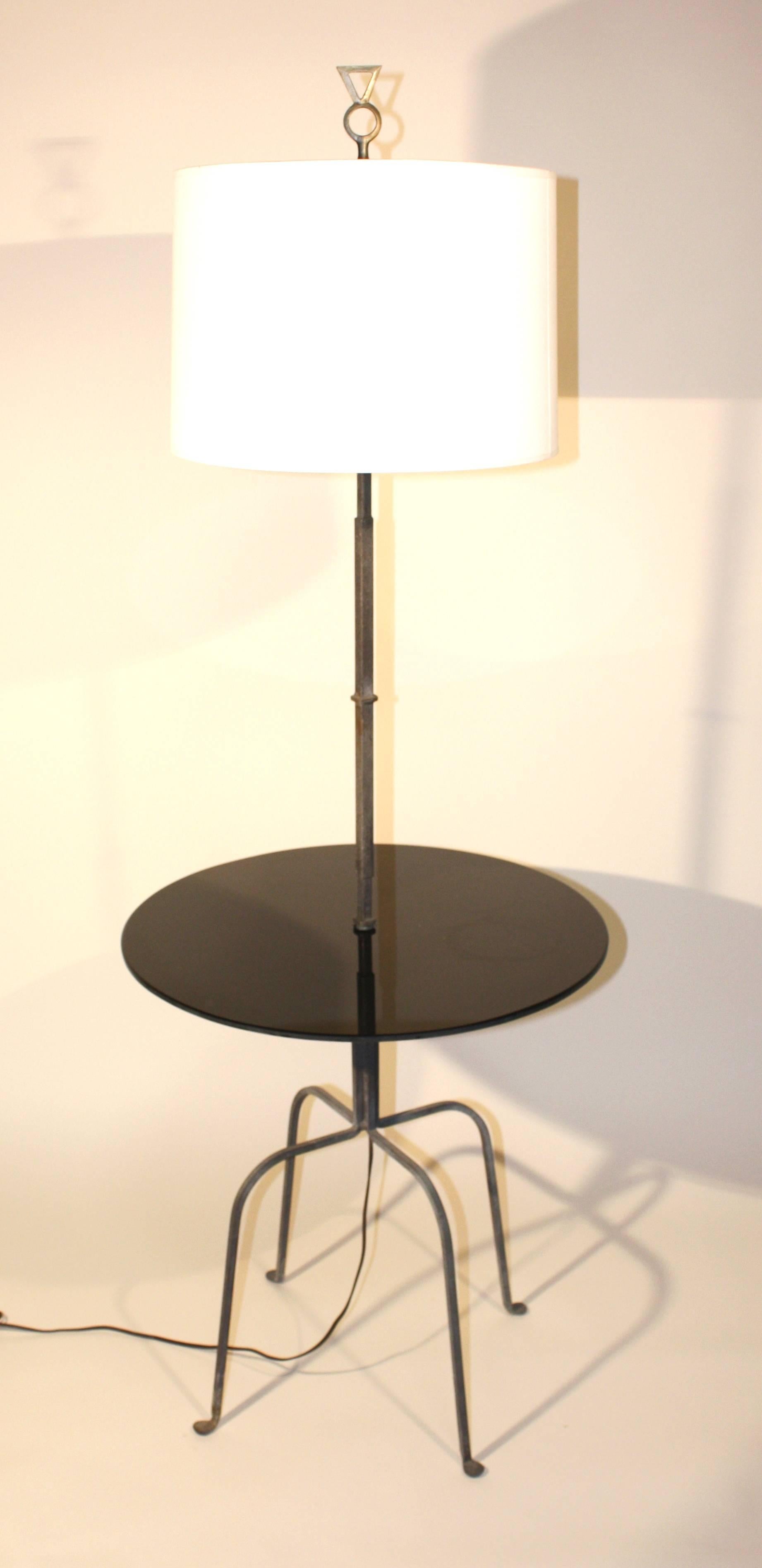 A modernist lamp table in wrought iron and black glass, circa 1970, in the manner of Tommi Parzinger.