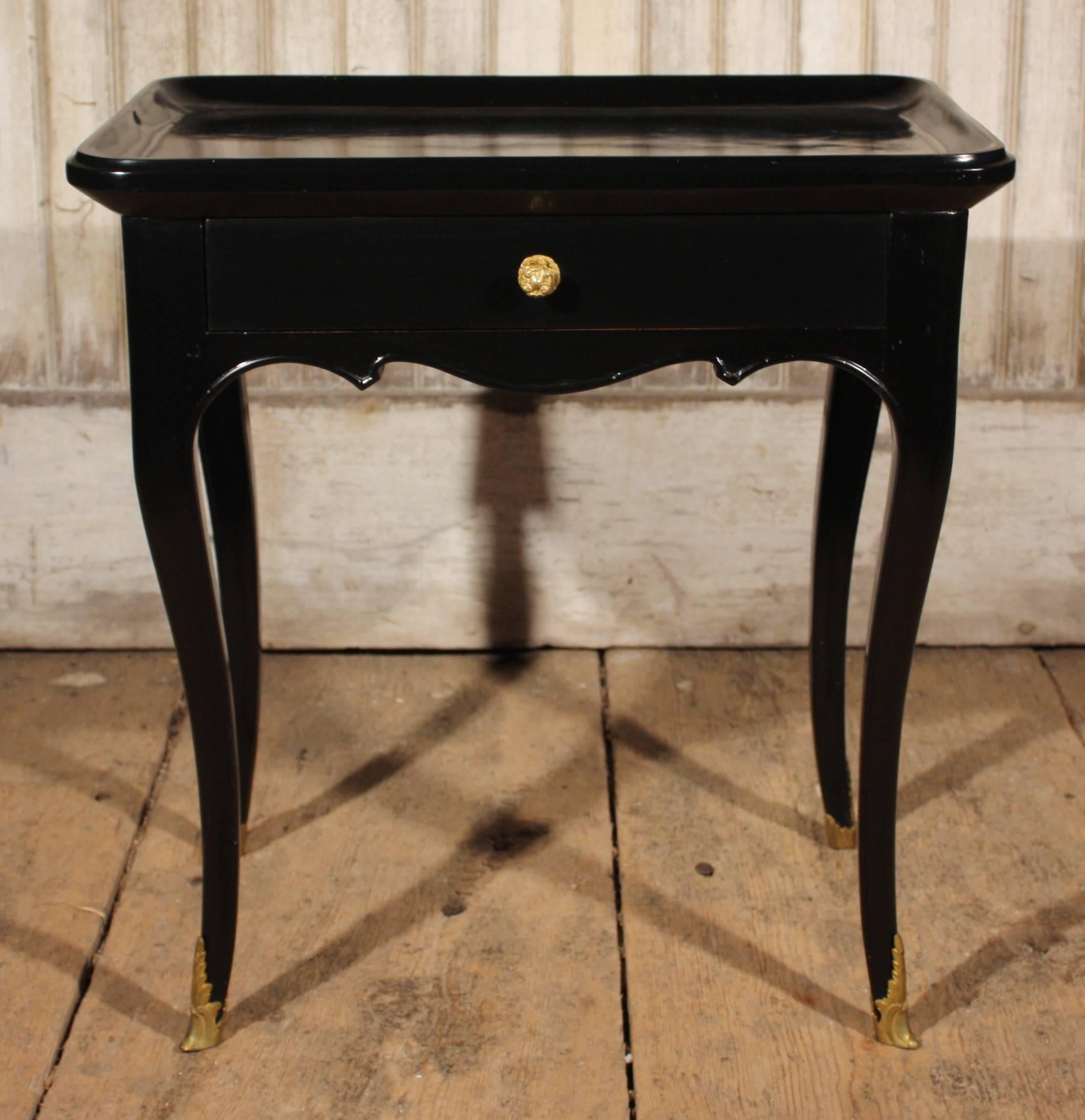A late 18th century Louis XV side table in black lacquer with a single drawer, cabriole legs and a scalloped apron. The top is dished out to serve as a "vide poche" (empty your pockets).  The piece has fine gilt bronze sabots and drawer