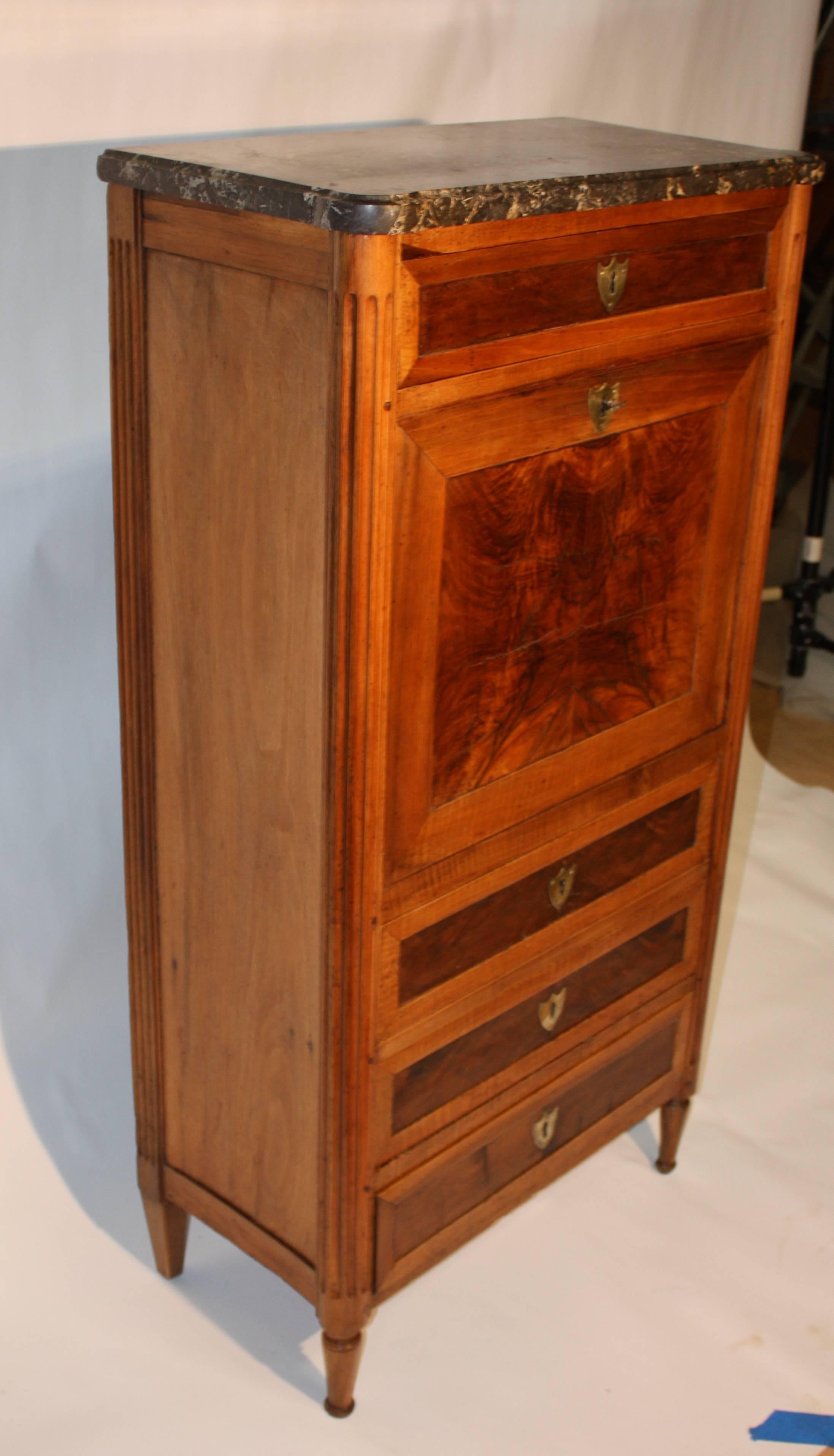 A charming and petite French secretaire abatante (drop-front secretary desk), Louis XVI period, circa 1790, in light walnut with inset burled walnut veneer drawer and desk fronts. The interior has three small drawers with an upper open compartment,
