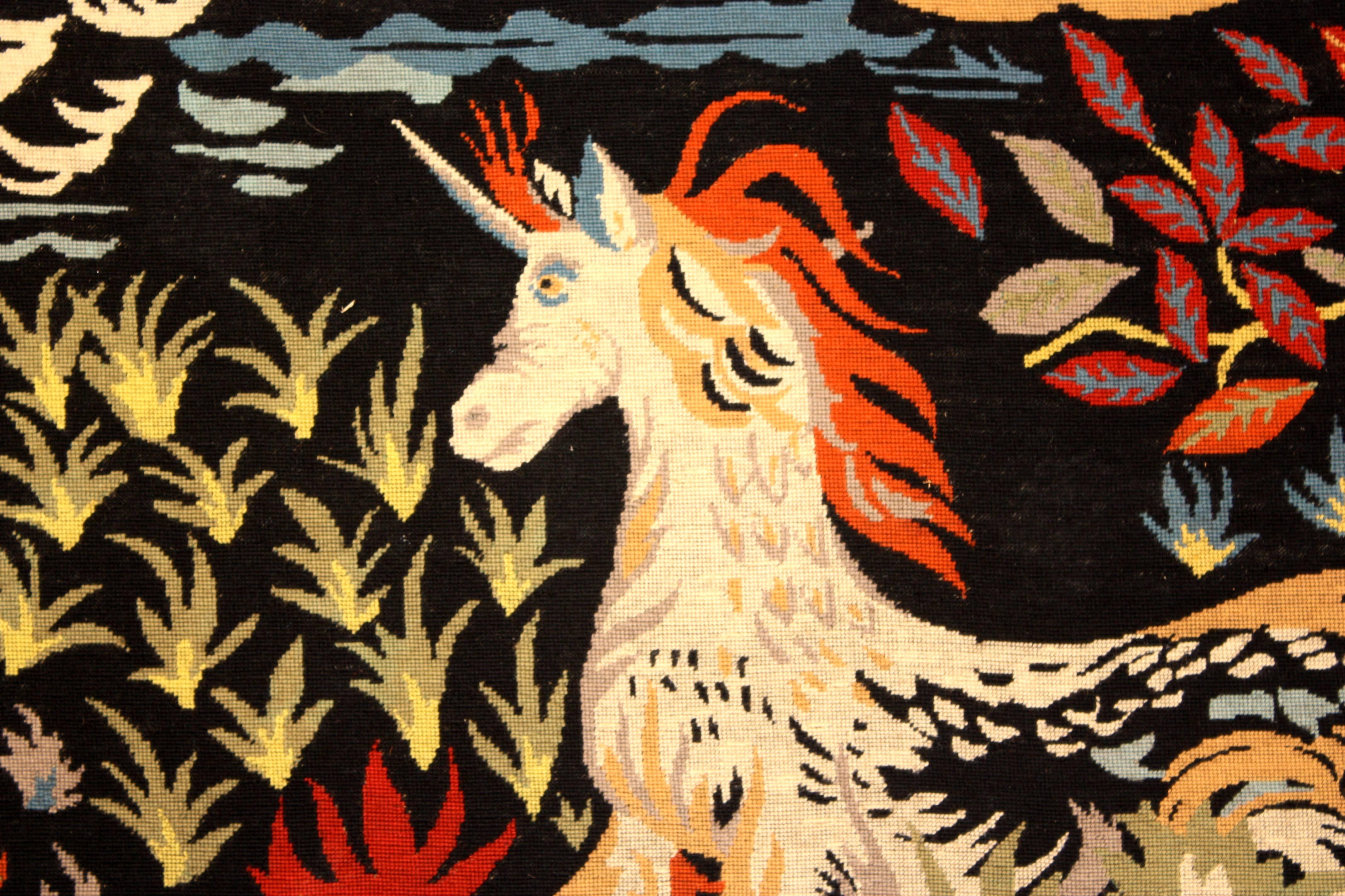 A rare needlepoint tapestry depicting a unicorn and rabbit with various plants and flowers, done in the surrealist style by Jean Picart Le Doux (1902-1982), circa 1950, France.