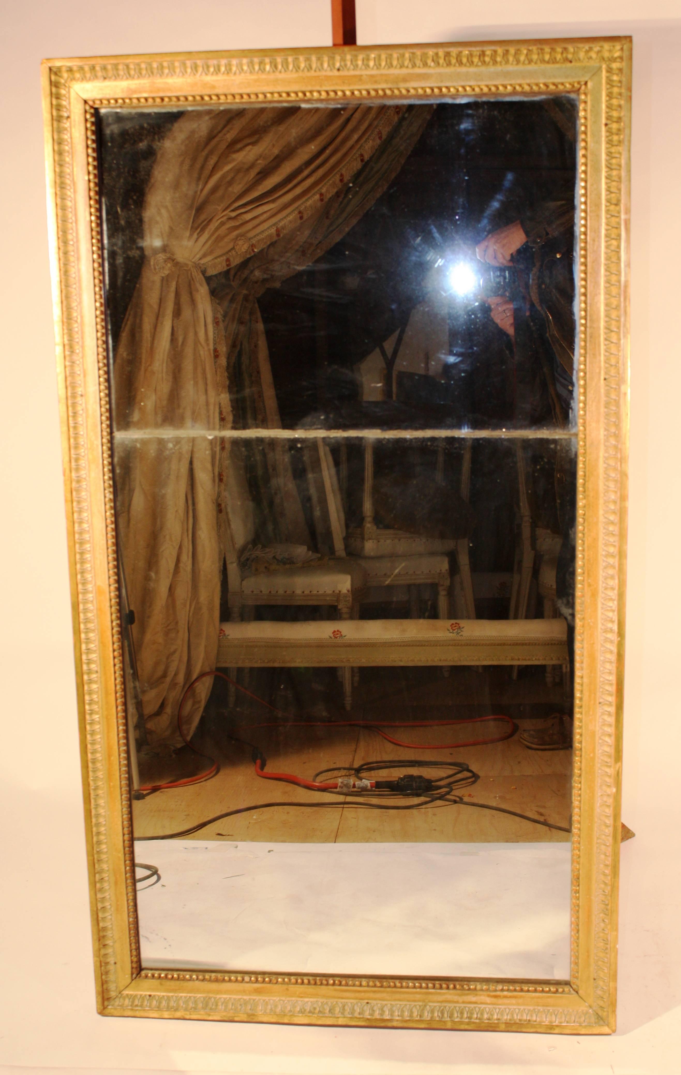A fine Louis XVI period gilt-wood mirror, late 18th century, with two-part mercury plate (original) in excellent condition. The gilded frame bordered in acanthus leaf decoration with a beaded inner border.