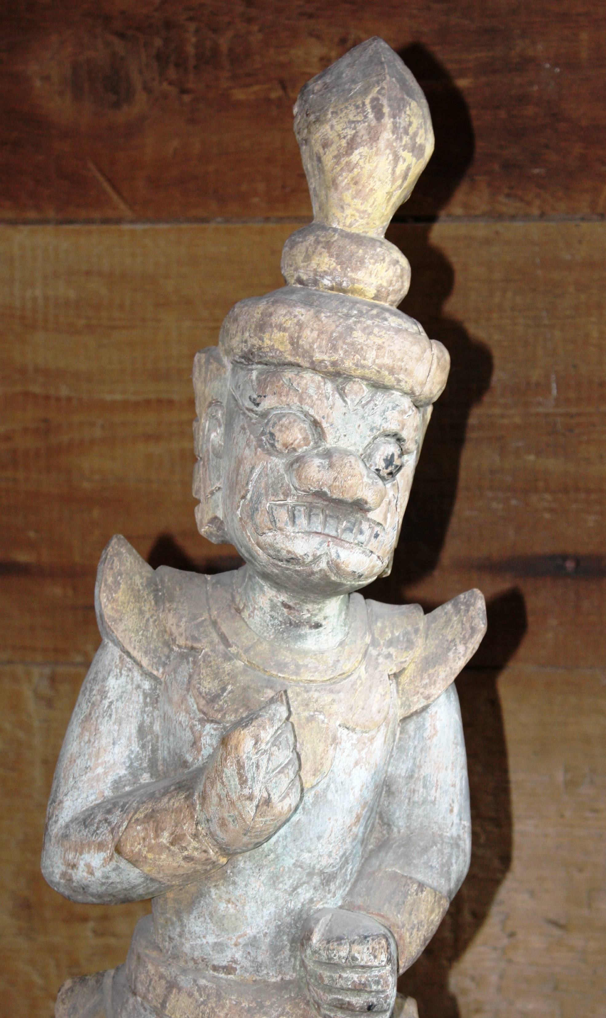 A pair of Balinese carved wood statues depicting Hunaman, late 18th century or earlier, traces of old paint, now bleached by the sun and elements.