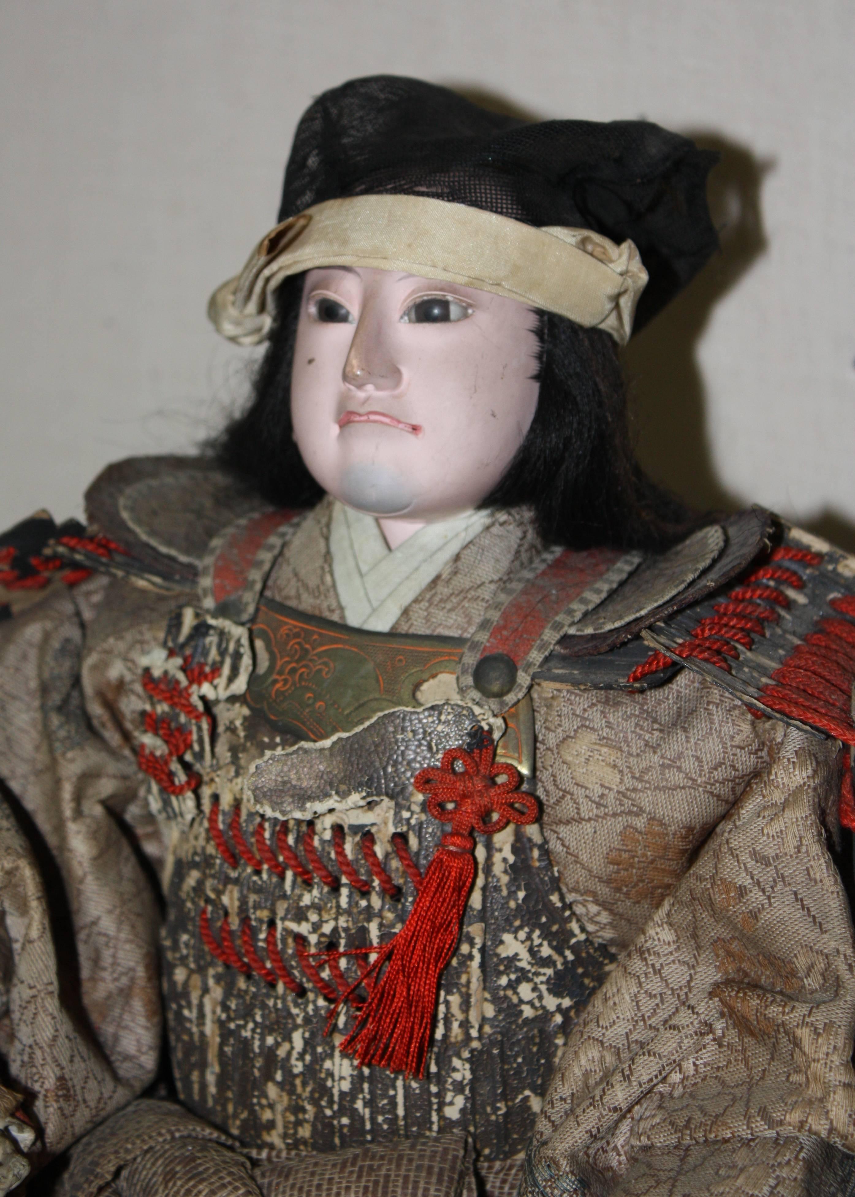 A wonderful Meiji period Japanese samurai doll with porcelain face and hands with armor and period costume, late 19th century.