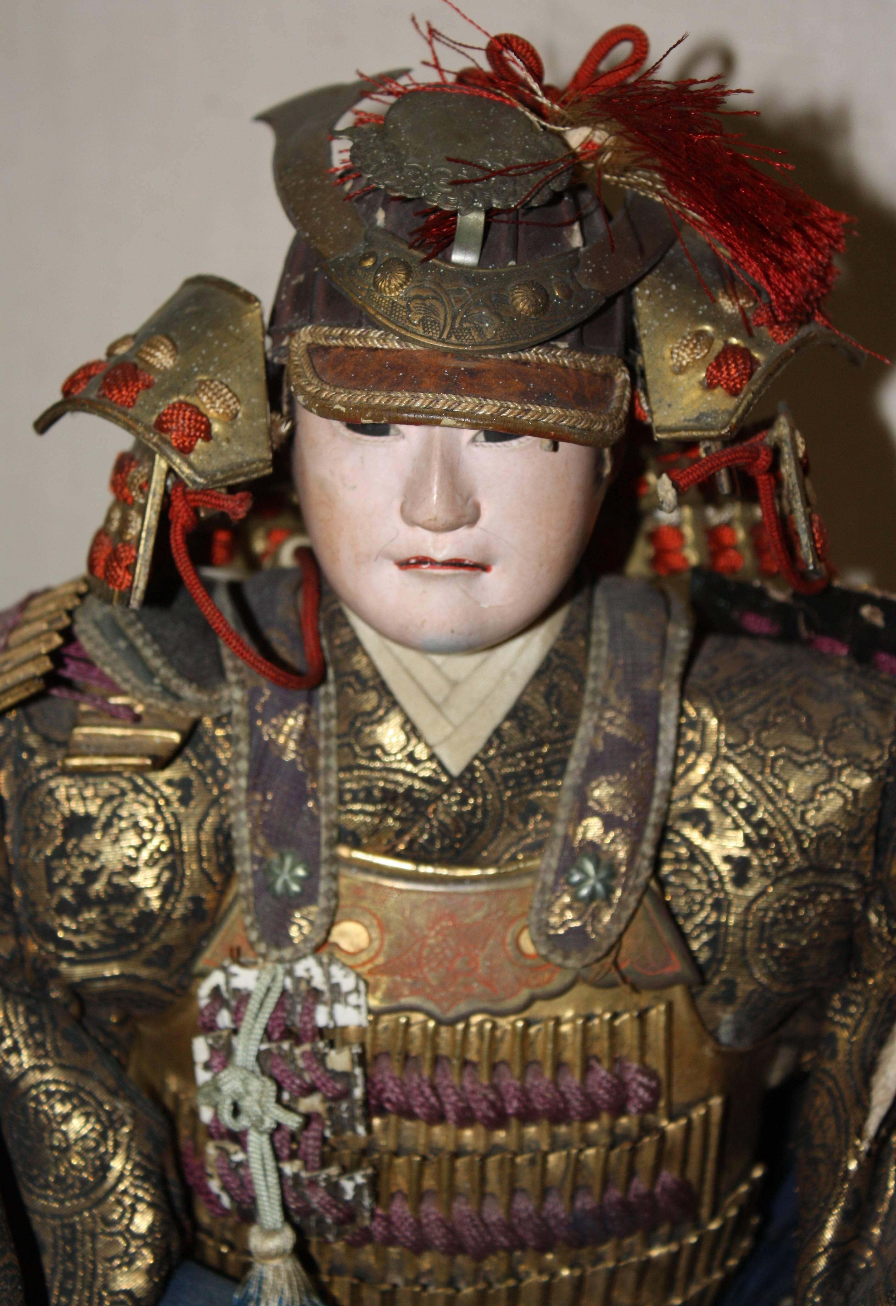A large and expressive Japanese Samurai doll, Meiji period, late 19th century, in armor and period costume, with porcelain face and hands.