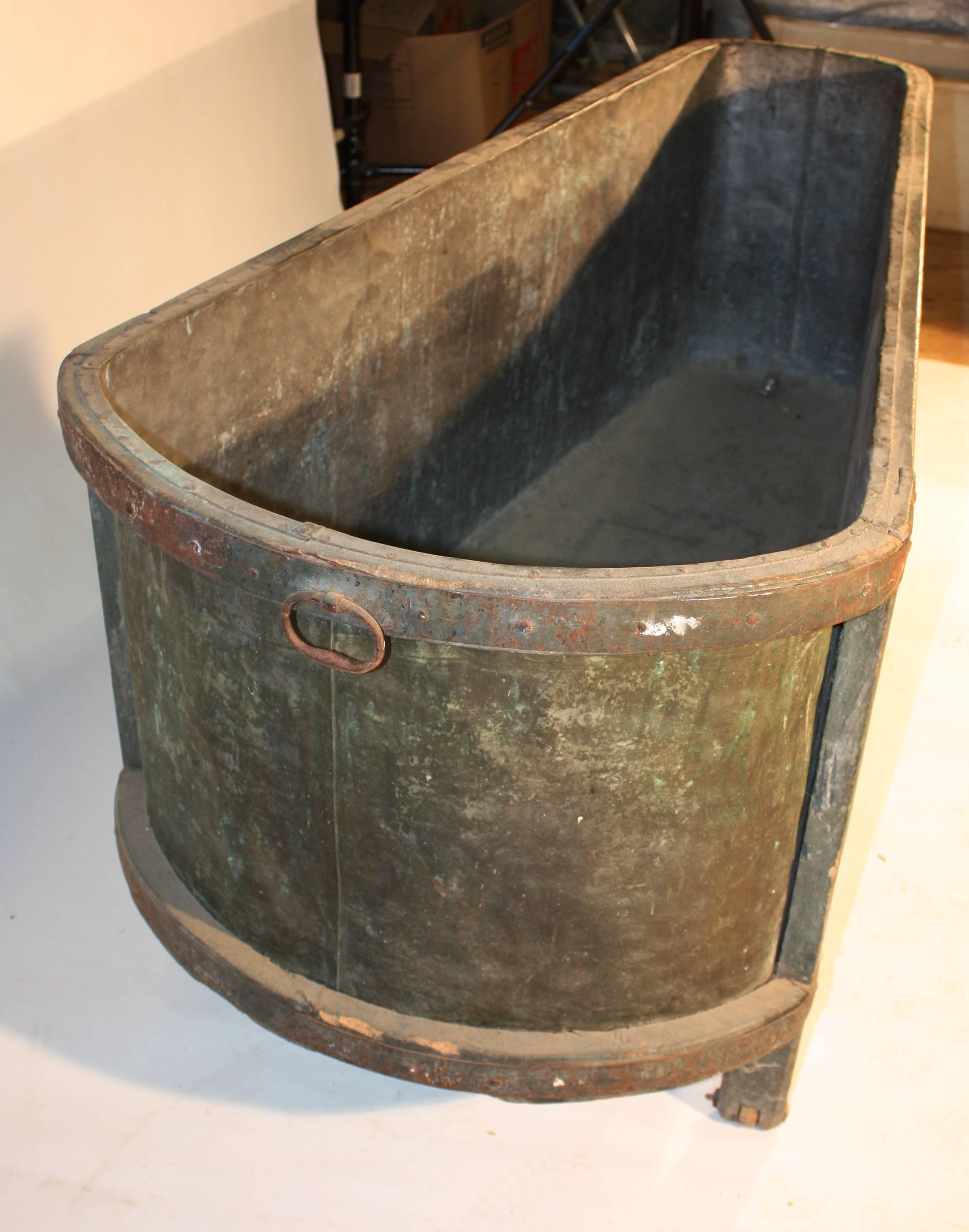 A rare French Louis XVI period (circa 1780) bathtub in original green painted finish with wrought iron handles, zinc lining, carved wooden wheels, and a brass spigot.
A great piece for prop rentals or for use as a unique planter.