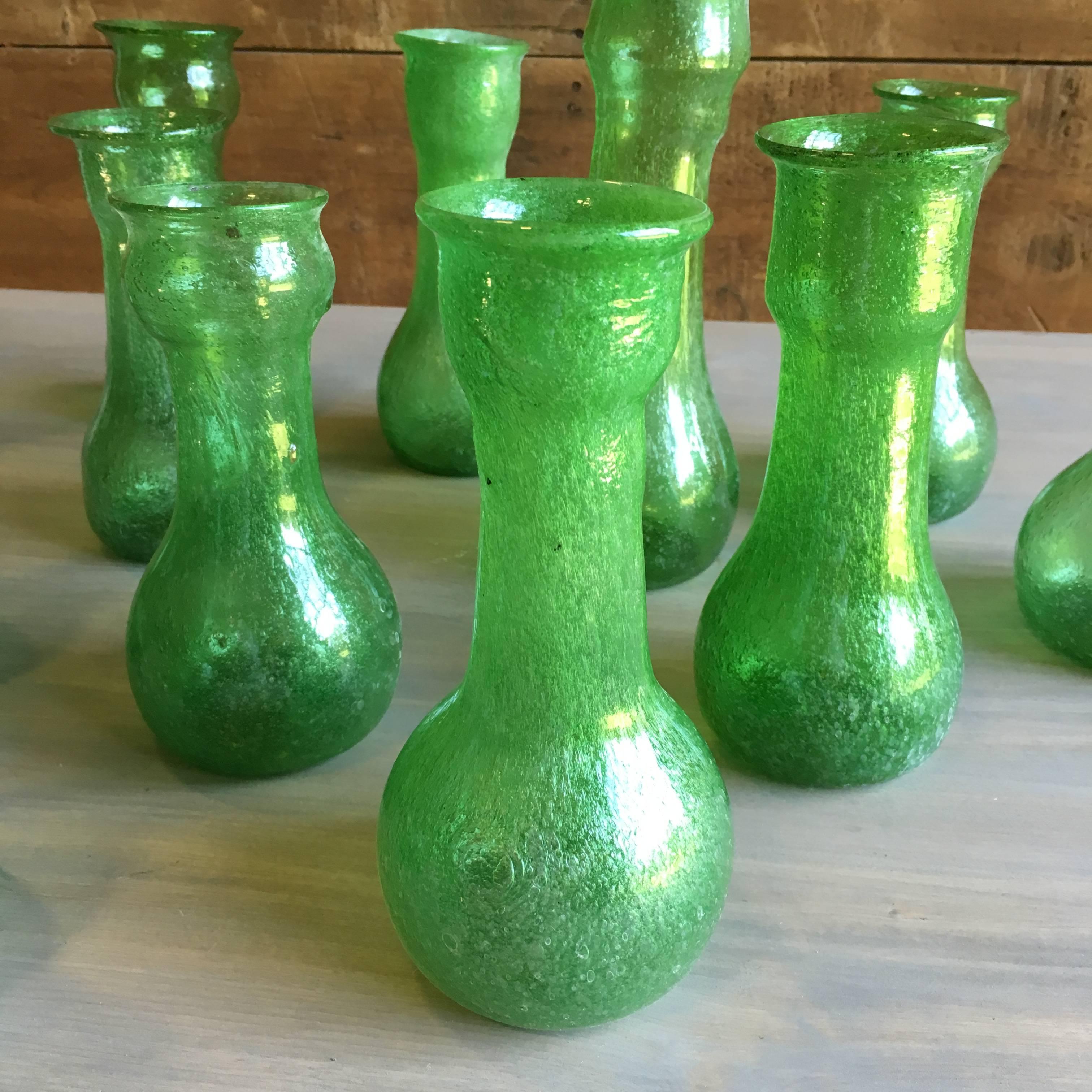 An unusual collection or 12 blown glass vases or bottles in bright green glass with seed bubbles, mid-20th century from Herat, Afghanistan.