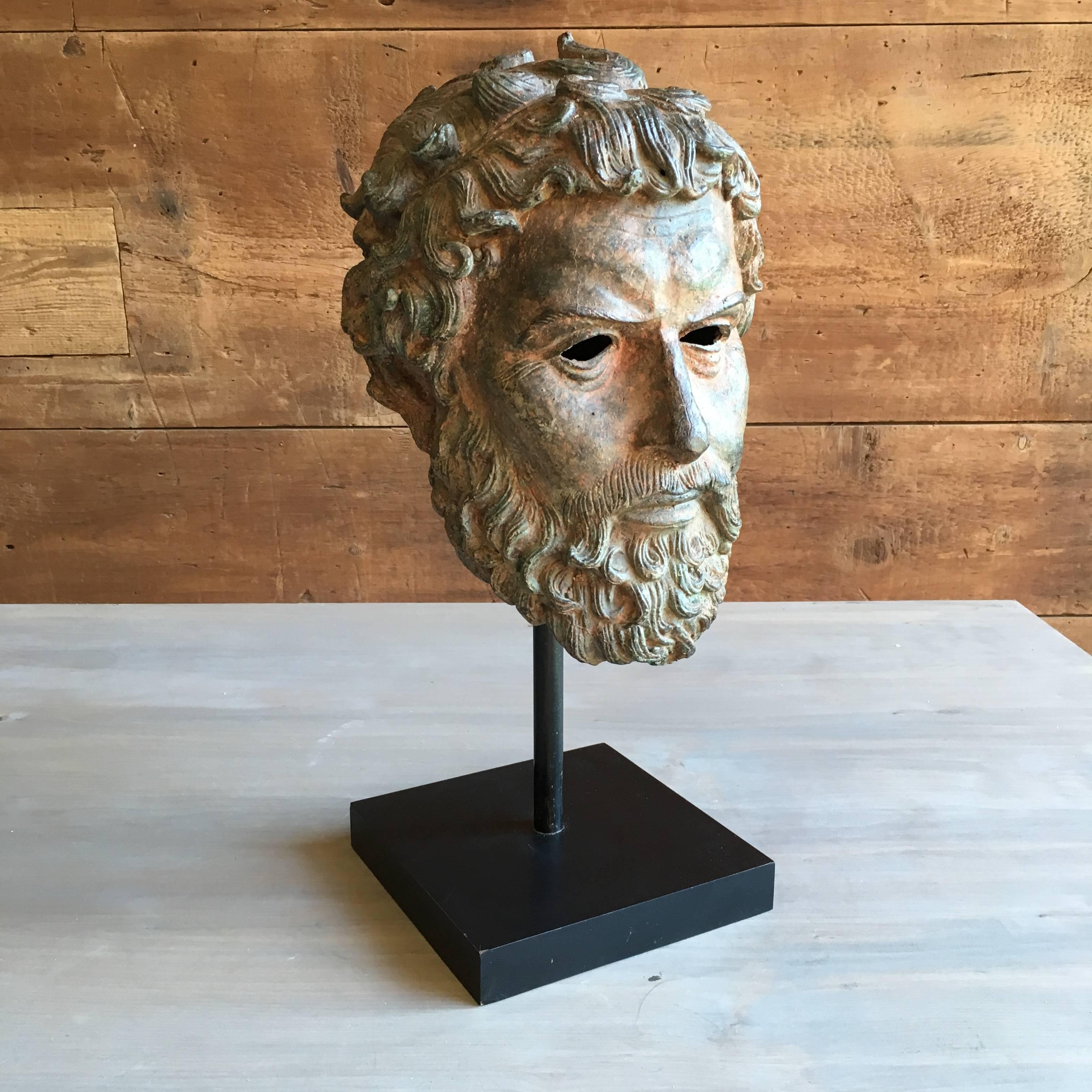 A classical bust of a bearded man in bronze on a custom stand, after the antique, finely cast with great patina.